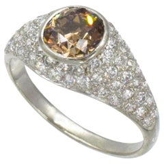 Anello con diamante colorato e montatura in pavé di diamanti.