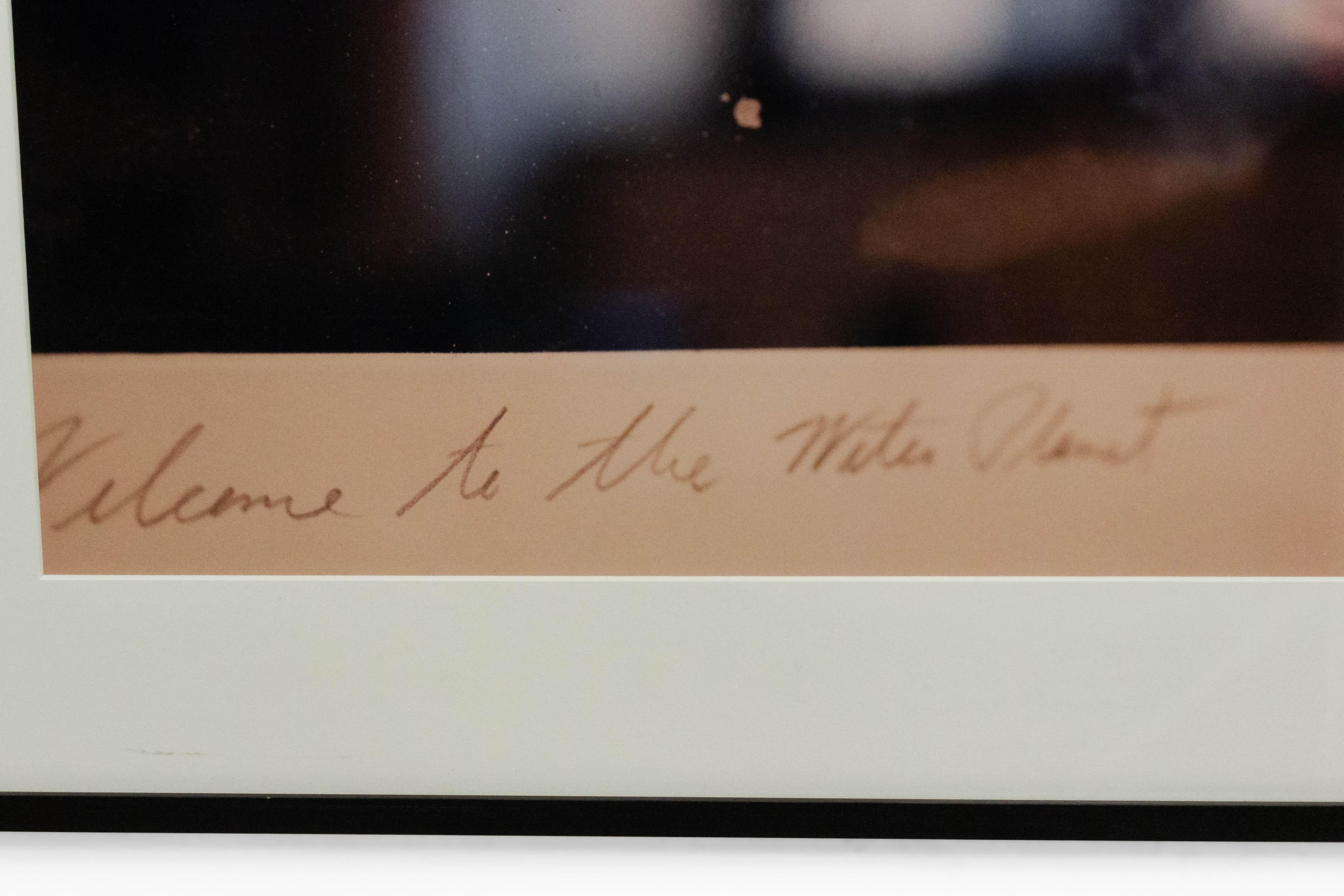 Color photograph in a black frame of a detail of a cropped photograph with handwritten script. Photograph by Shelley Harrison.
 