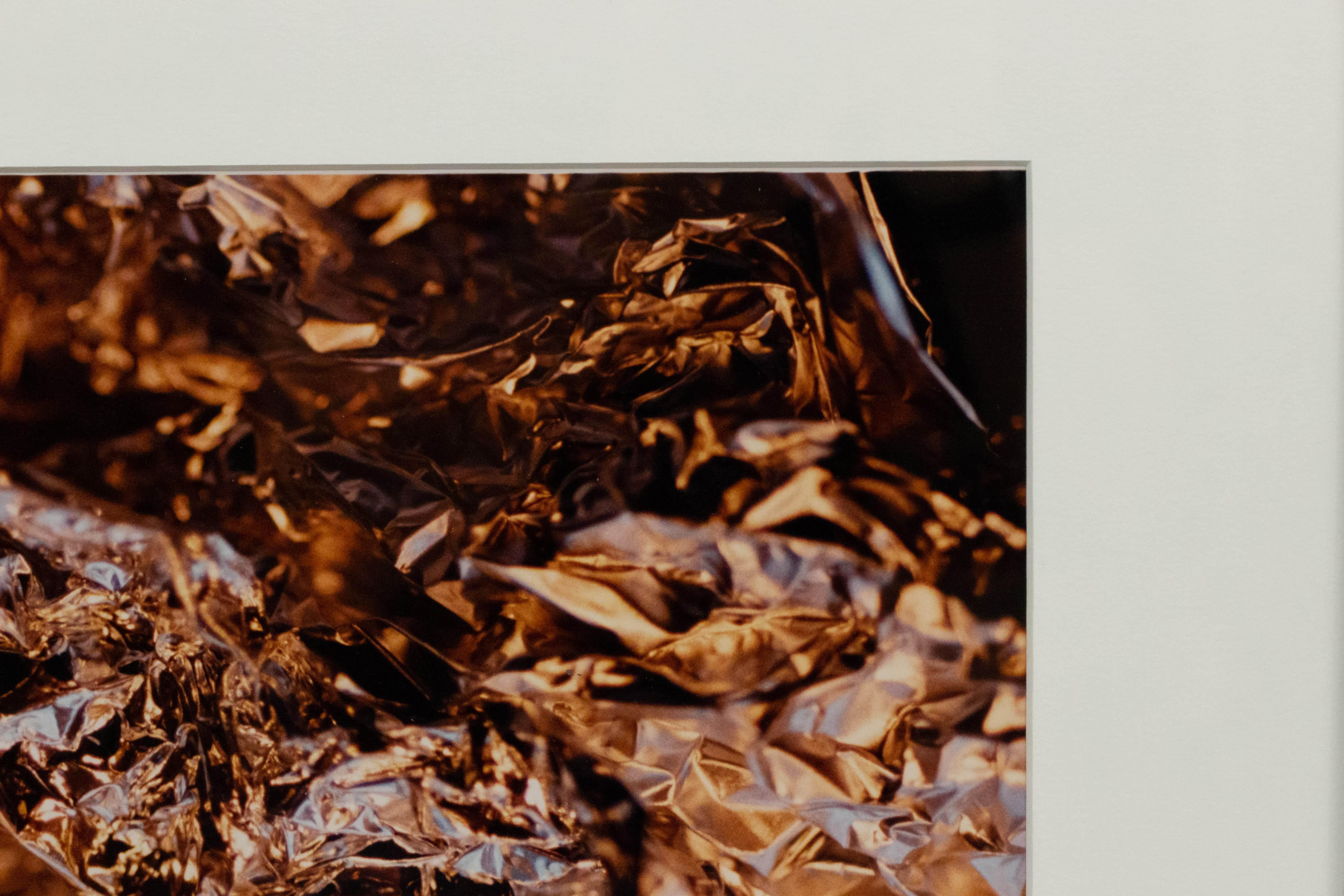 Color photograph of a detail of silver foil with a black frame and a white matte. Photograph by Shelley Harrison.
    