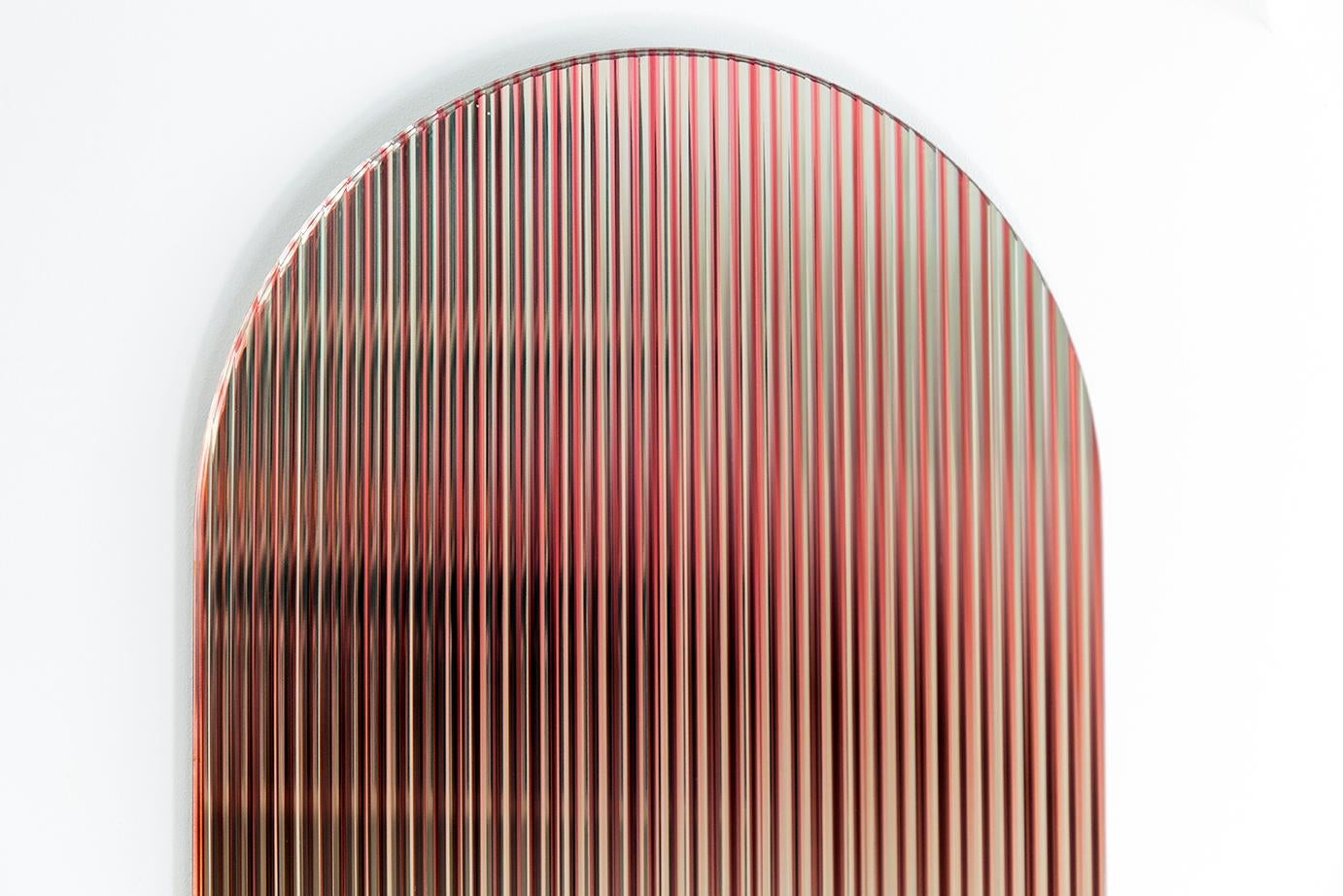 Die reflektierende, farbige, gewellte Glasplatte - entworfen, um eine Farbpalette in den Raum zu bringen - reflektiert das Licht im Raum und fügt Bewegung und Farbe hinzu, während sie abstrahierte Reflexionen erzeugt. Das Werk streut das Licht durch