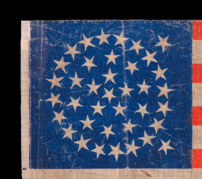 38 Star Antique American Flag With An Off-balace Medallion Configuration On A Brilliant Blue Canton, Made In The Period When Colorado Was The Most Recent State To Join The Union, 1876-1889.

38 star American parade flag, block-printed by hand on