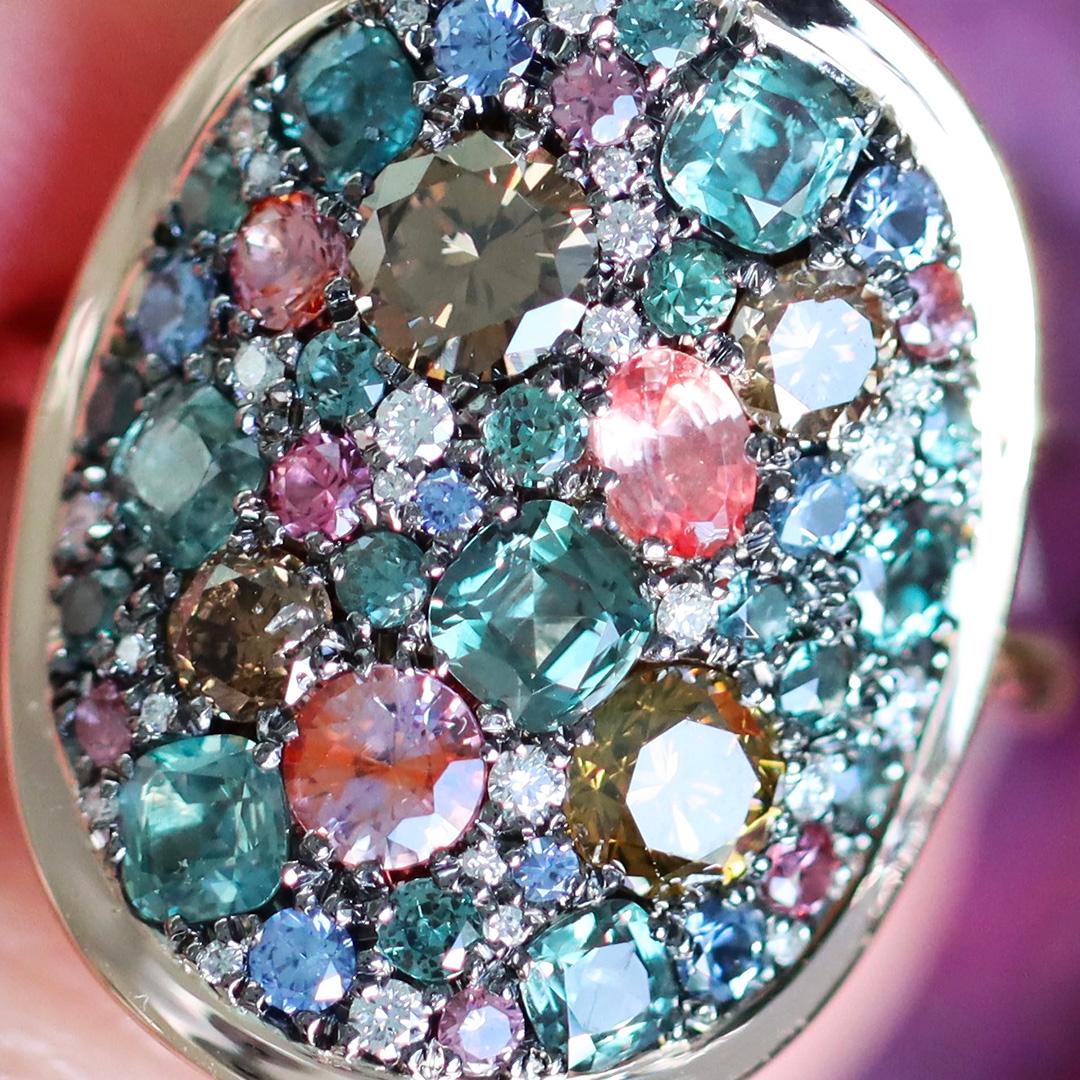 Discover the beauty and precision of Belgian craftsmanship in this Alexandrite, Padparadscha Sapphire, unheated blue Sapphire and Diamond ring by jewellery designer 'Joke Quick'. 

At the heart of this ring, Created entirely by hand without any