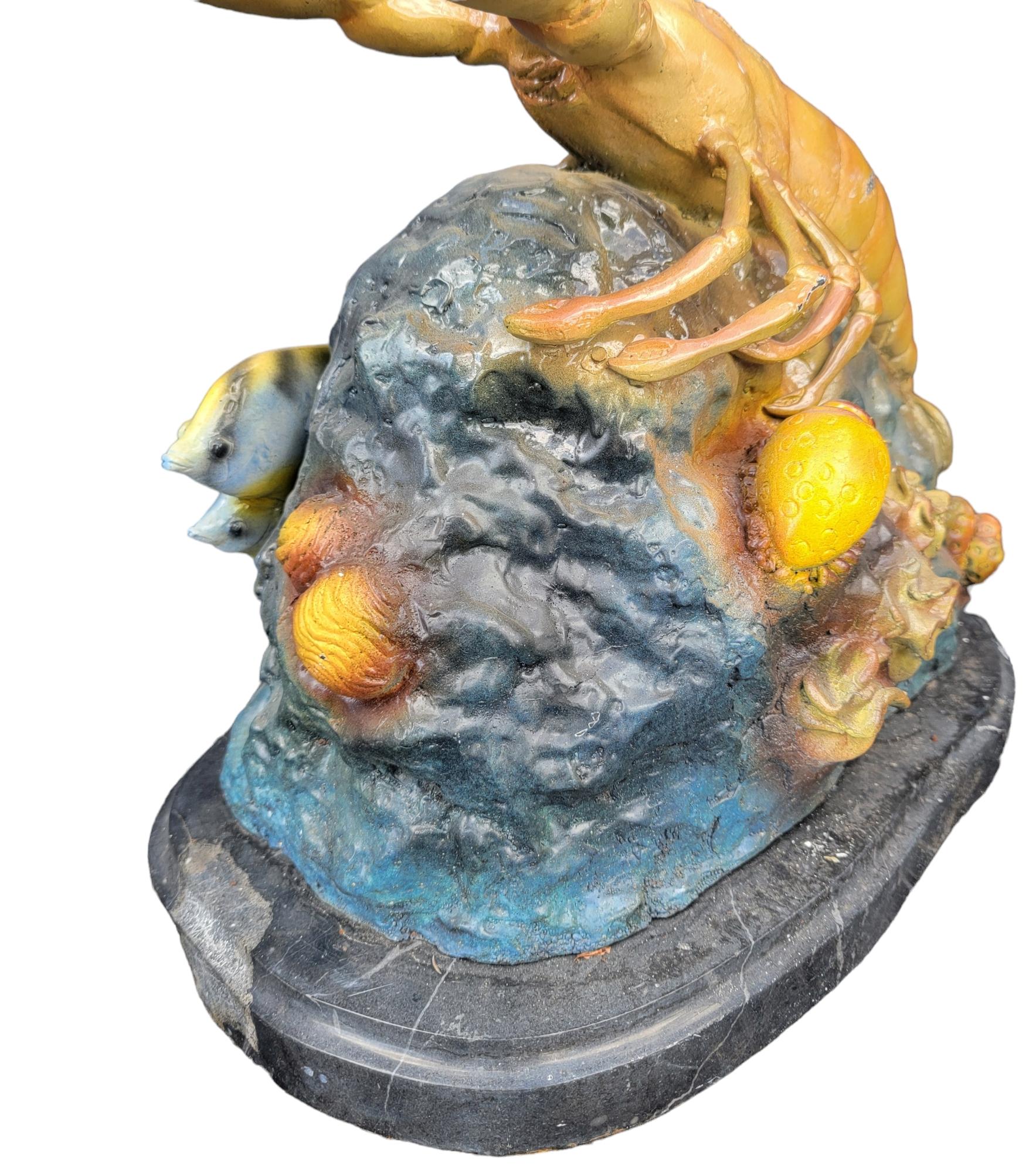Bronze , Colored Patinaed Lobster Over Coral Base Statue. This wonderful full of life  lobster statue shows the prowess and strength of the lobster over its reef. The Lobster is king of this hill. The coral and fish on this setting are placed