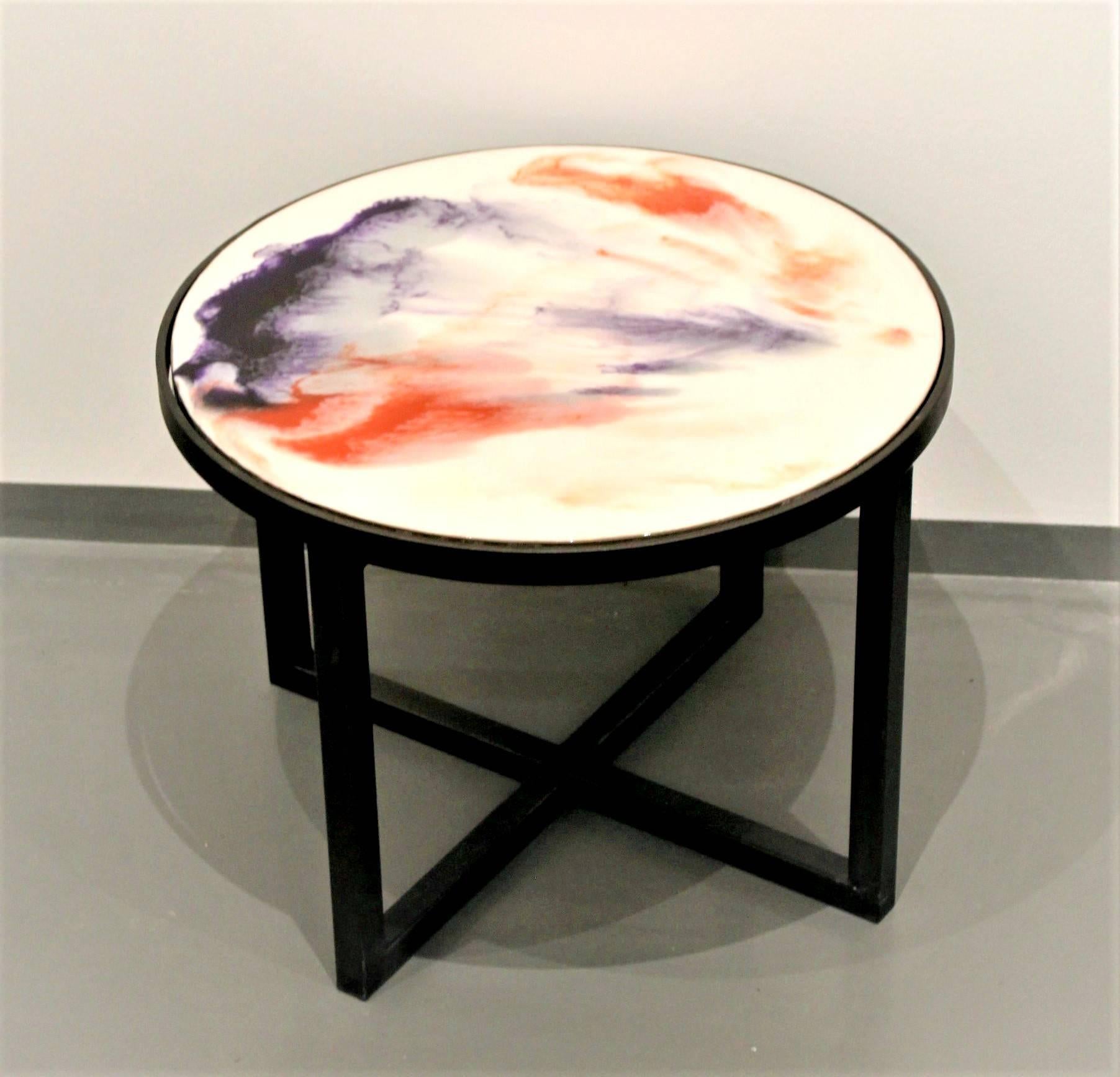 Part of Viscosity Art & Resin Gallery art furniture collection, this colorful coffee table is an one of a kind creation. The tabletop is made of hand painted layers of colored resin on wood. Vivid orange and muted violet, floating on cloudy white