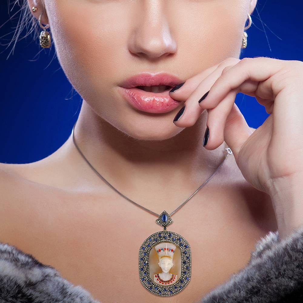 Lovely Egyptian Colored Shell Cameo Pendant with Diamonds and Blue Sapphire in silver. This pendant has openable bayle so you can slide your favorite chain through.

18k:0.39g
Diamond: 3.81ct
Sapphire-5.25cts 
Cameo-27.25

