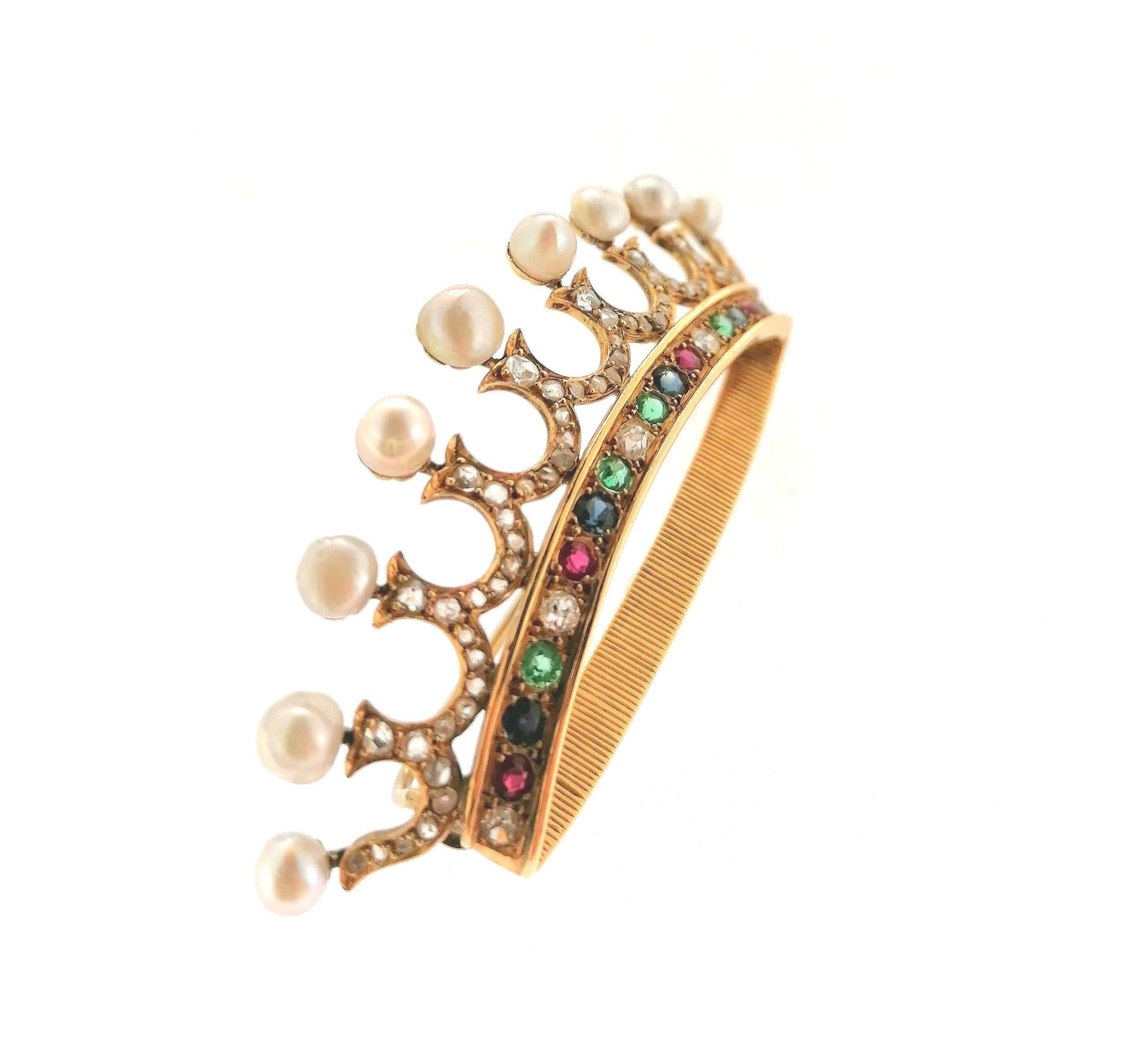 Magnificent 18 karats yellow gold crown brooch with two rubies, two emeralds, two saphires and sixty rose cut diamonds that have 0.55 carats estimated. Natural fine pearls give a special touch of class to this marquis crown. It has 9 with this