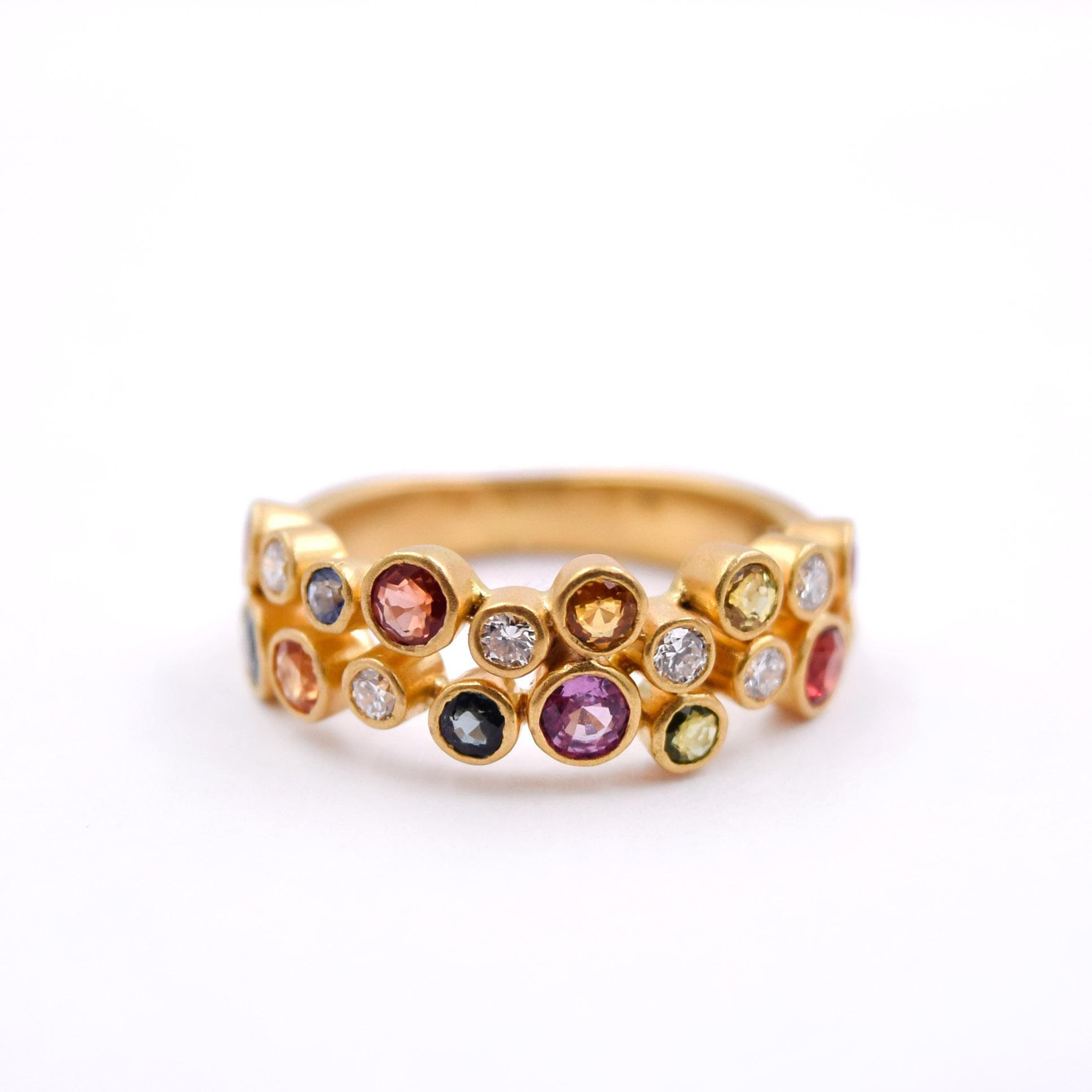 Beautiful Sapphire and Diamond Band by Kanwar Singh. 
This ring features sparkles of all colors. Carefully set white diamonds and colored sapphires are set halfway around the 18k yellow gold ring. The stones are set in bezel settings, totaling 0.71