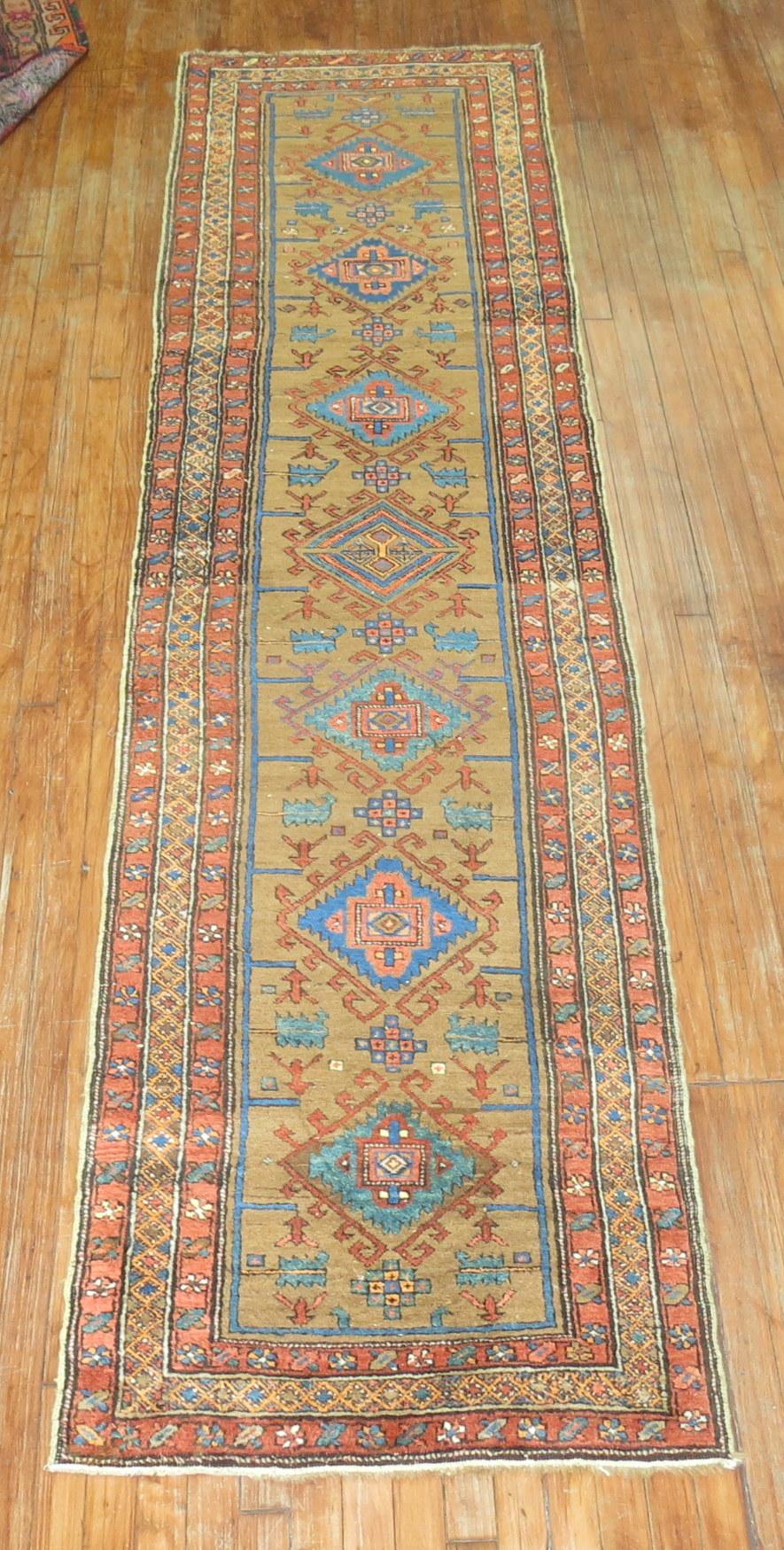 1930s Persian Heriz runner. Camel field, medallions in soft blue and green. Orange teal and orange accents throughout.

Measures: 2'7