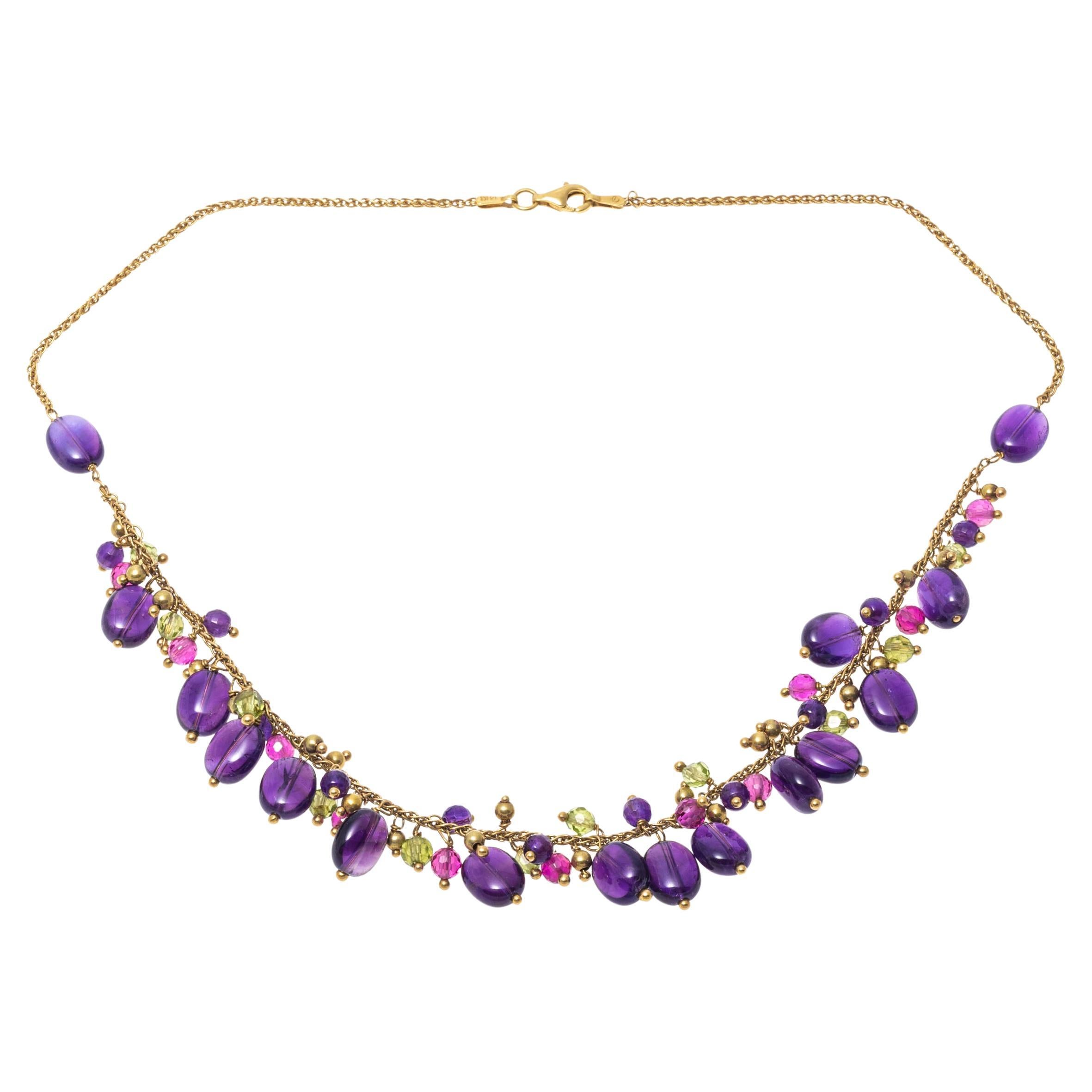 Colorful and unique this wheat style chain necklace presents clusters of stone beads. The beads are crafted from polished rubies, amethysts and peridots. The necklace secures with a lobster claw style clasp.
Marks: 14K Italy
Dimensions: 16 1/2