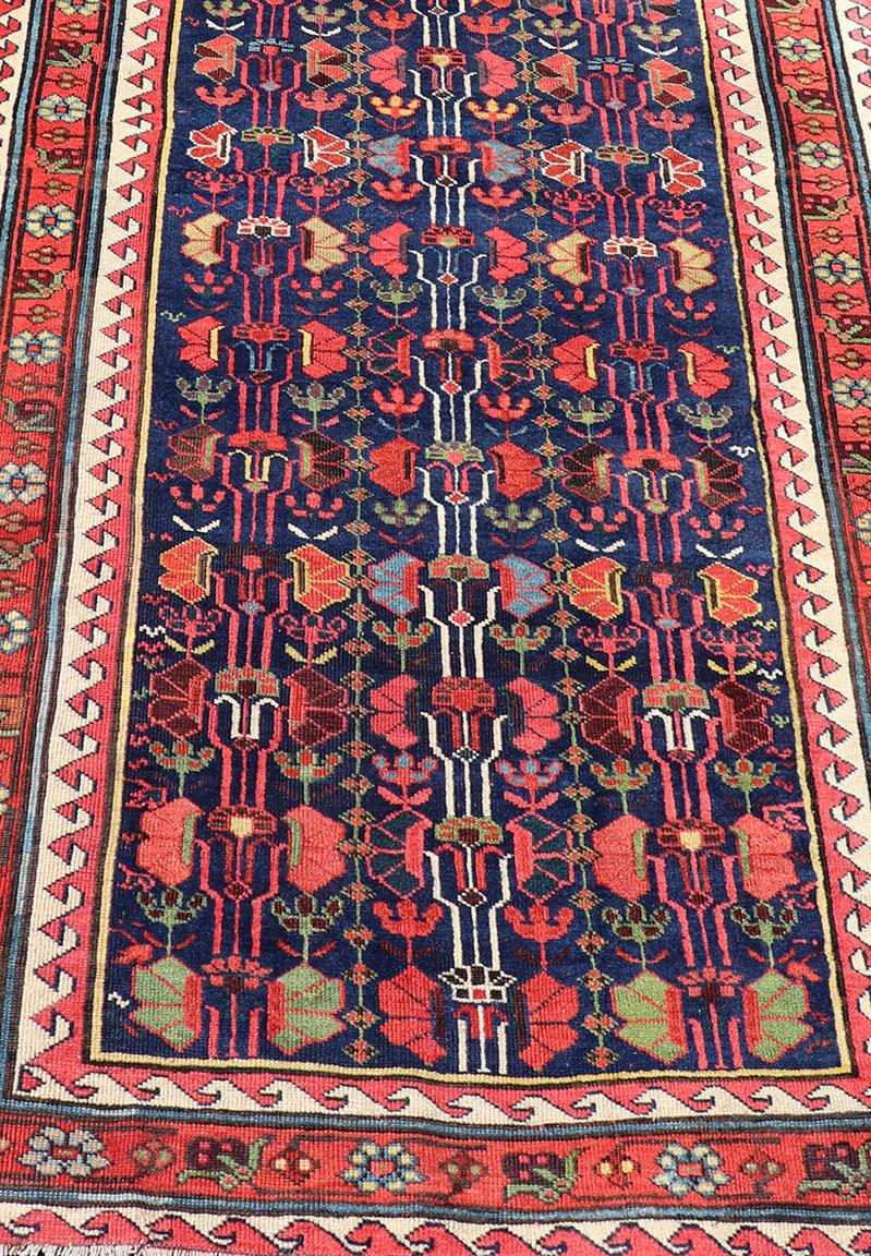 Annodato a mano Runner lungo Kazak antico e colorato con motivi multi geometrici su campo blu in vendita