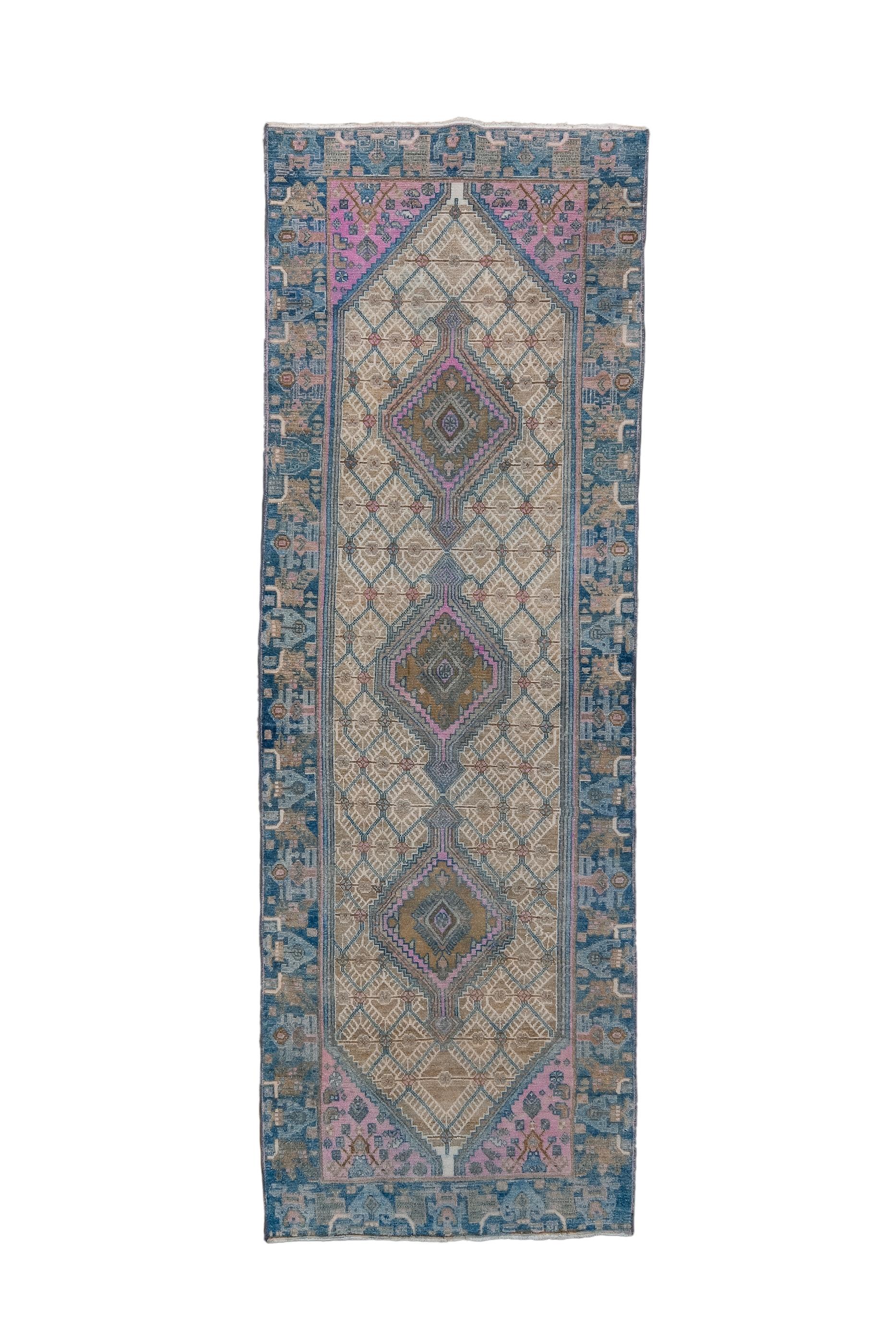 This colourful kellegi (long rug) shows an end-pointed subfield densely packed with uniform fringed diamonds, and supporting a tripartite run of nested and serrated diamonds. Sky blue field narrow along sides and widens to  flower-filled triangles