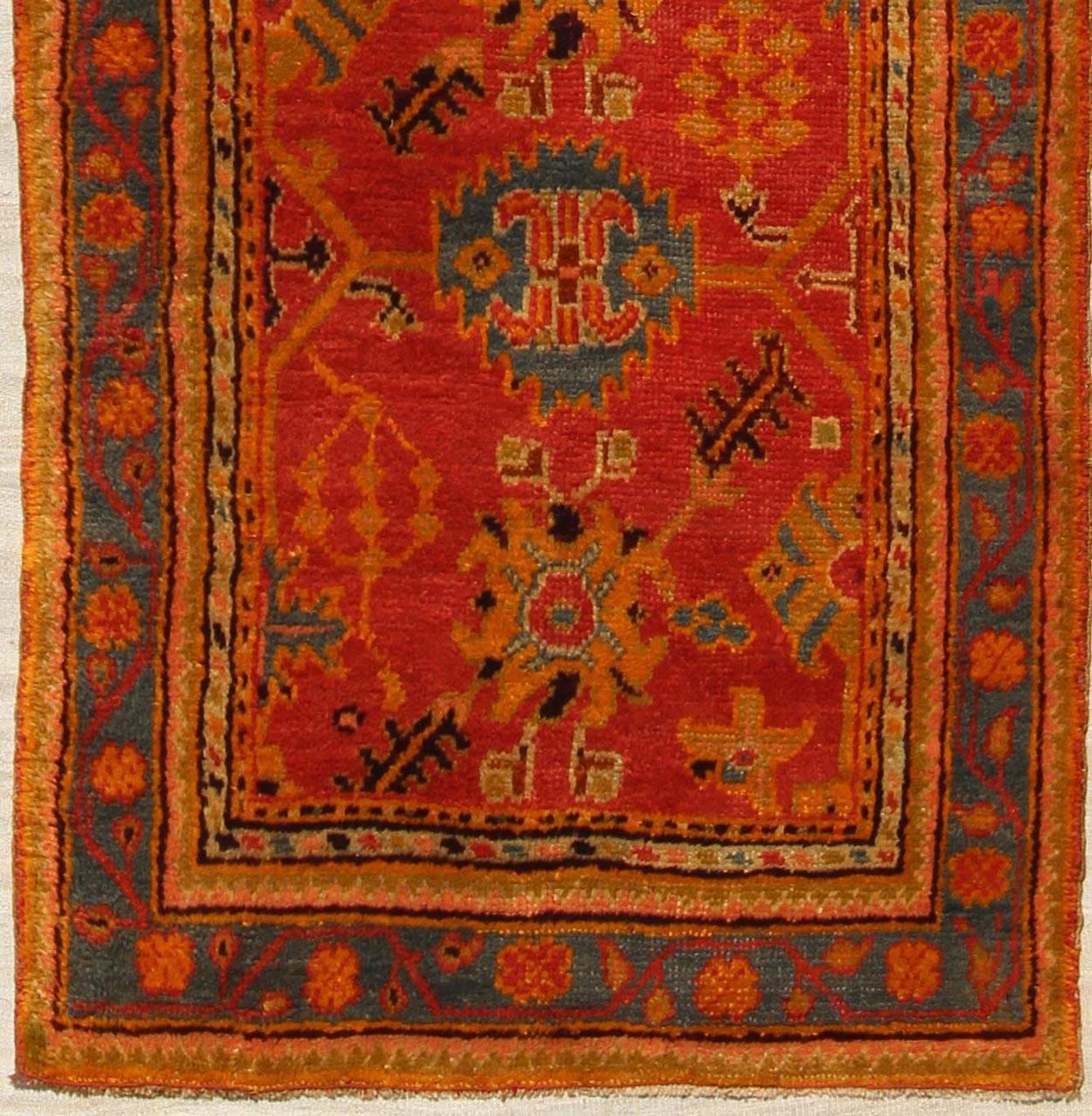 Red and tan and multi colors antique Turkish Oushak runner with sub-geometric tribal motifs, rug 16-1002, country of origin / type: Turkey / Oushak, circa 1910

This antique Oushak runner features a unique blend of cheerful colors and an