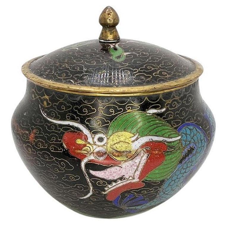 Un piccolo vaso cloisonné con motivo a drago in nero e coperchio abbinato. Il piccolo vaso a cineserie è realizzato in ottone o rame ed è impreziosito dal disegno di un drago cloisonné. I cloisonné sono un'arte che richiede molto tempo e che