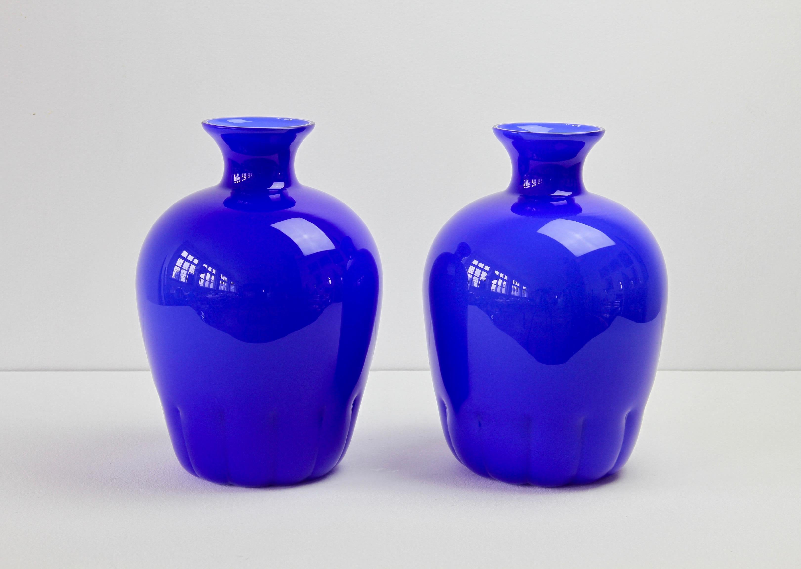 Colorful (colorful) pair of midcentury cobalt blue vases by Cenedese Vetri of Murano, Italy, circa 1970s-1990s. Particularly striking is the narrow necked round form with rippled bases, very similar to Napoleone Martinuzzi bowls for Venini in the