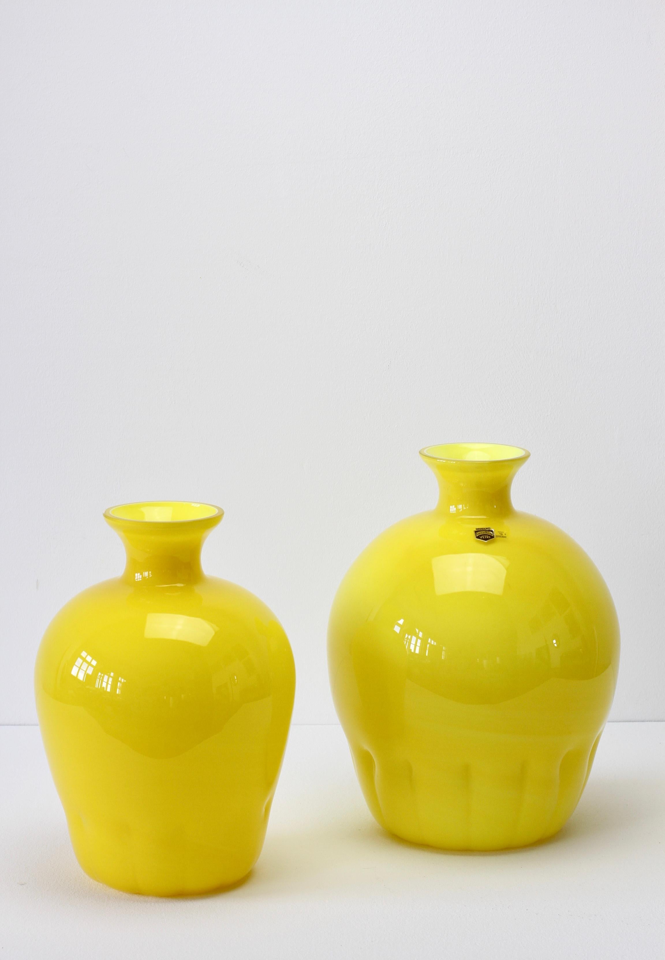 Buntes oder farbenfrohes Paar, Gruppe oder Ensemble von hellgelben Vasen im Stil der Jahrhundertmitte von Cenedese Vetri aus Murano, Italien, ca. 1990er Jahre. Besonders auffällig ist die runde Form mit schmalem Hals und geriffeltem Boden, die den