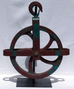 Colorful Dark Maroon and Teal Large Industrial Cast Iron Pulley on a Metal Base