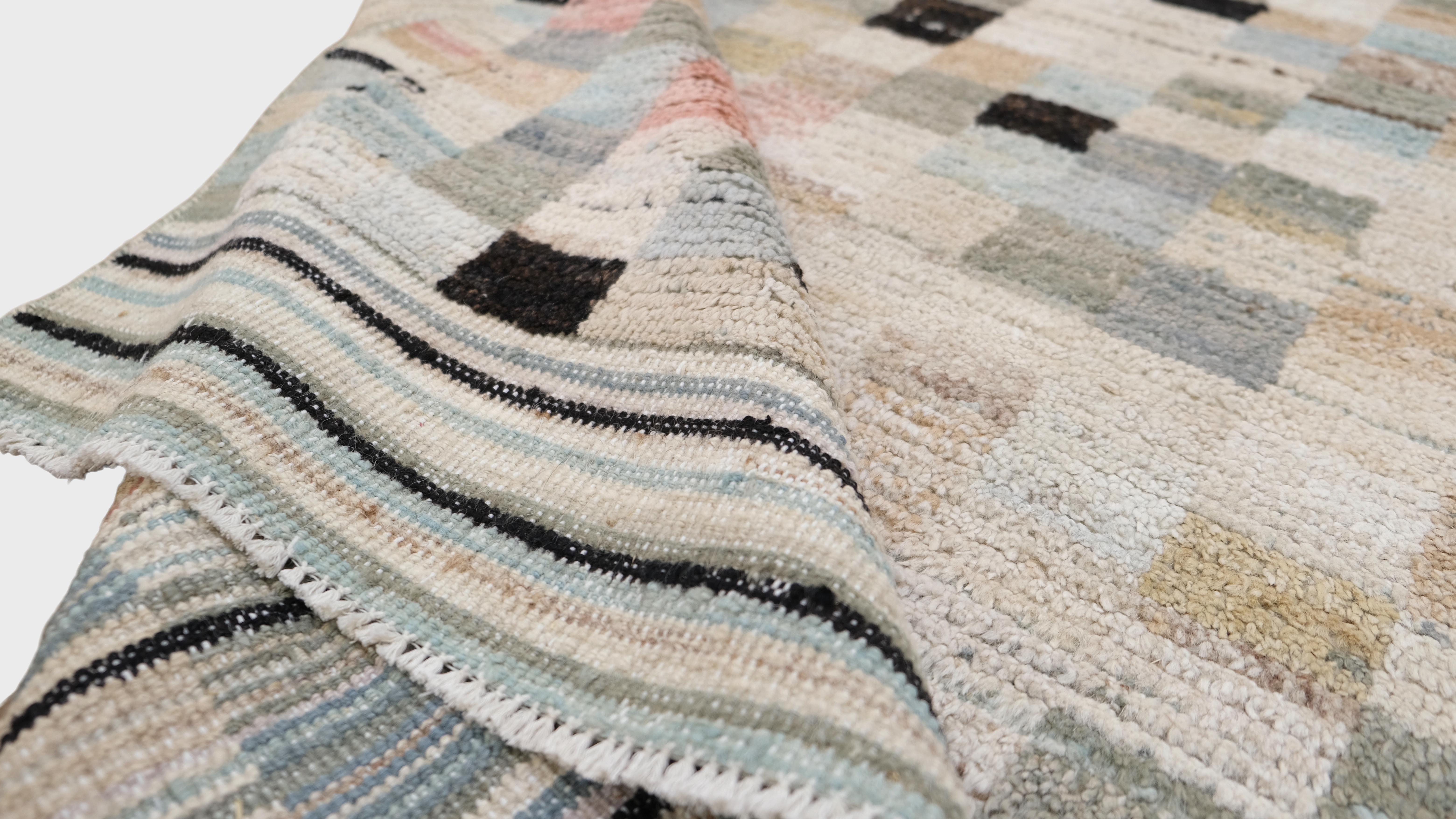 Featuring a contemporary design, this rug combines a variety of pastel and neutral tones—light blues, pinks, creams, light green and blacks—creating an eye-catching patchwork of small geometric squares. Its modern aesthetic lends itself well to