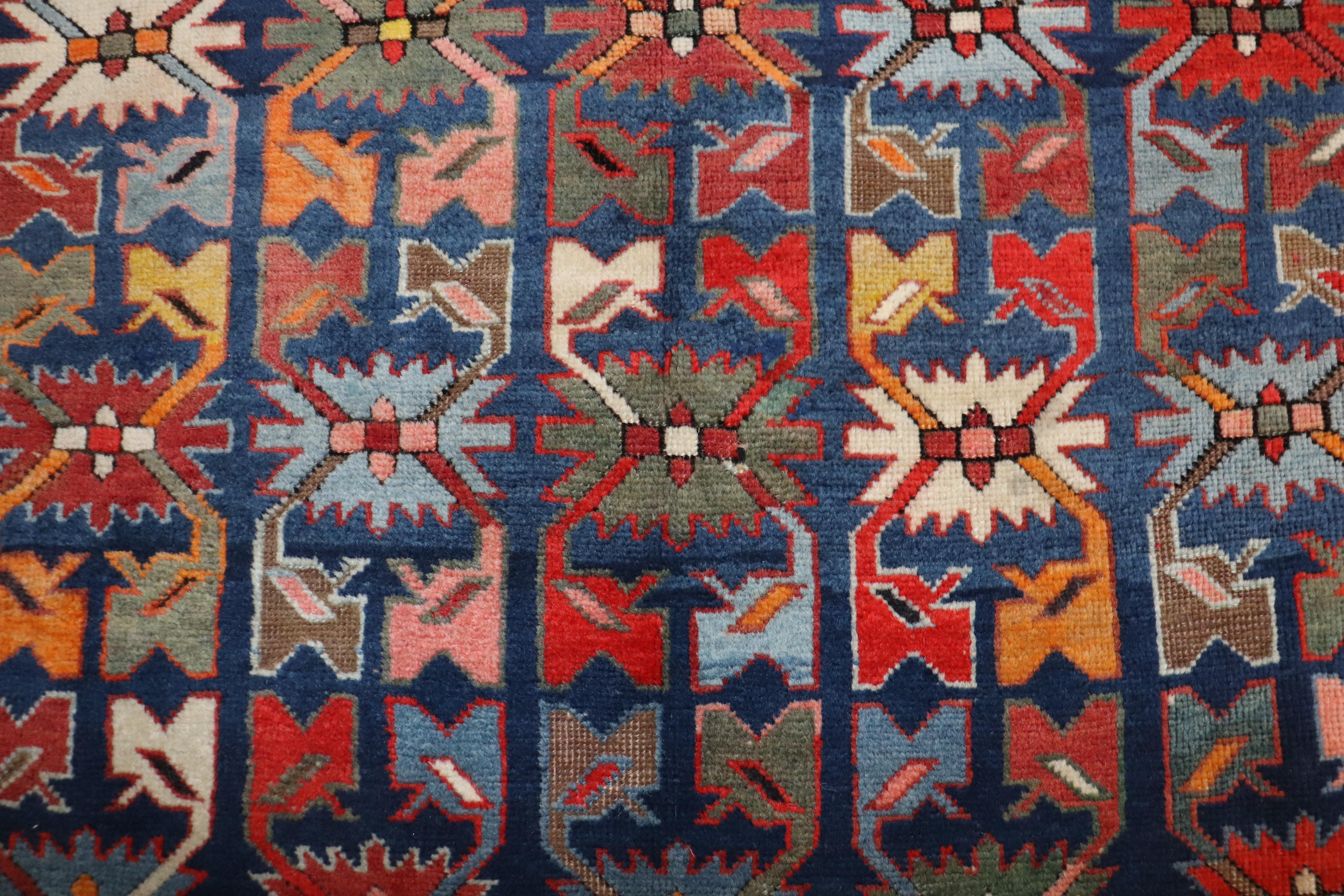 An early 20th century Caucasian Karabagh rug featuring a non-traditional motif in lively colors. The field is navy, green and tomato red accents. 

Measures: 3'11