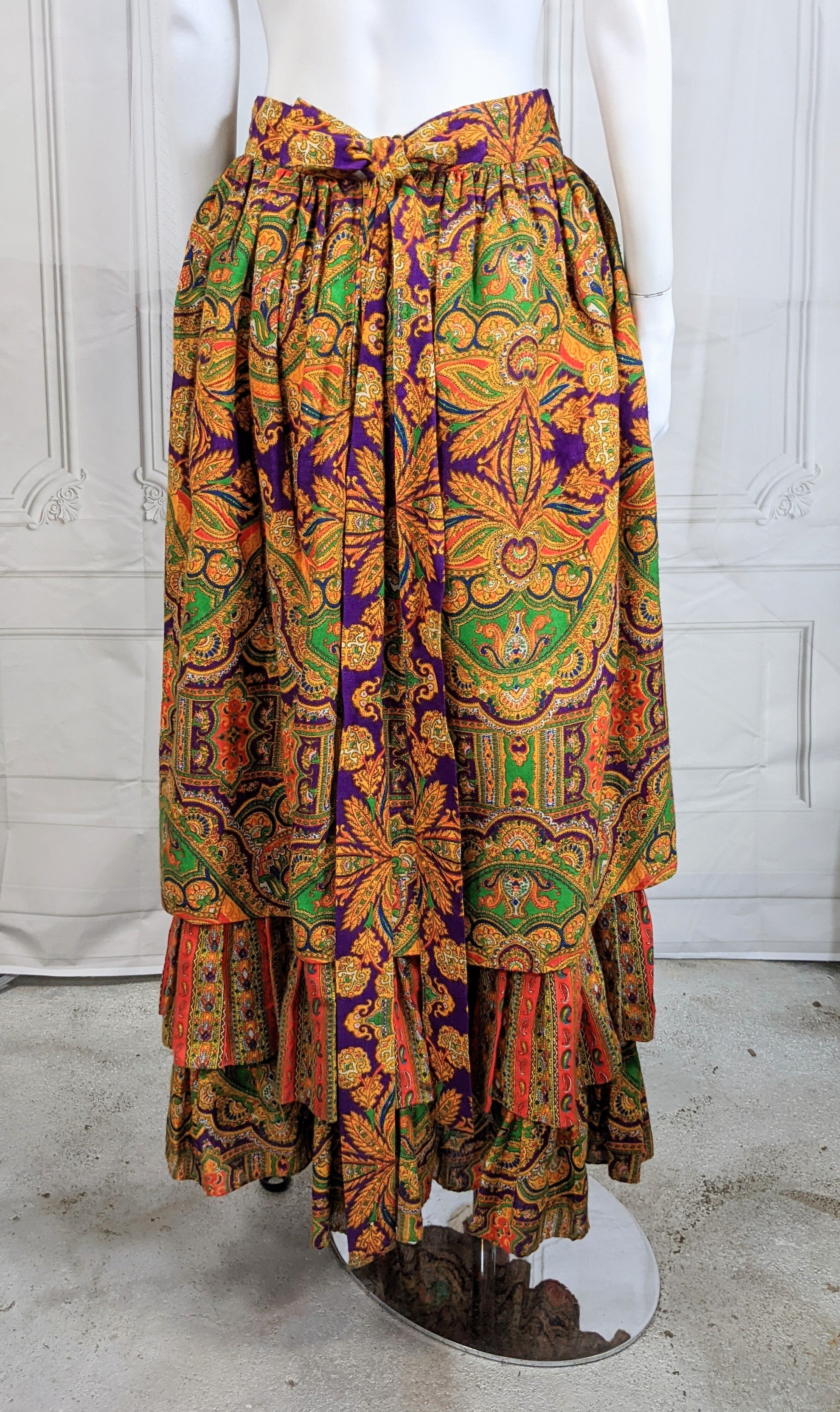 Folkloric Ruffled Skirt by Ellen Tracy circa 1970. Wonderfully colored vibrant paisley print in a dirndl shape over an attached petticoat with 2 rows of ruffles. The bottom ruffle matches the upper skirt and the center ruffle has a contrasting