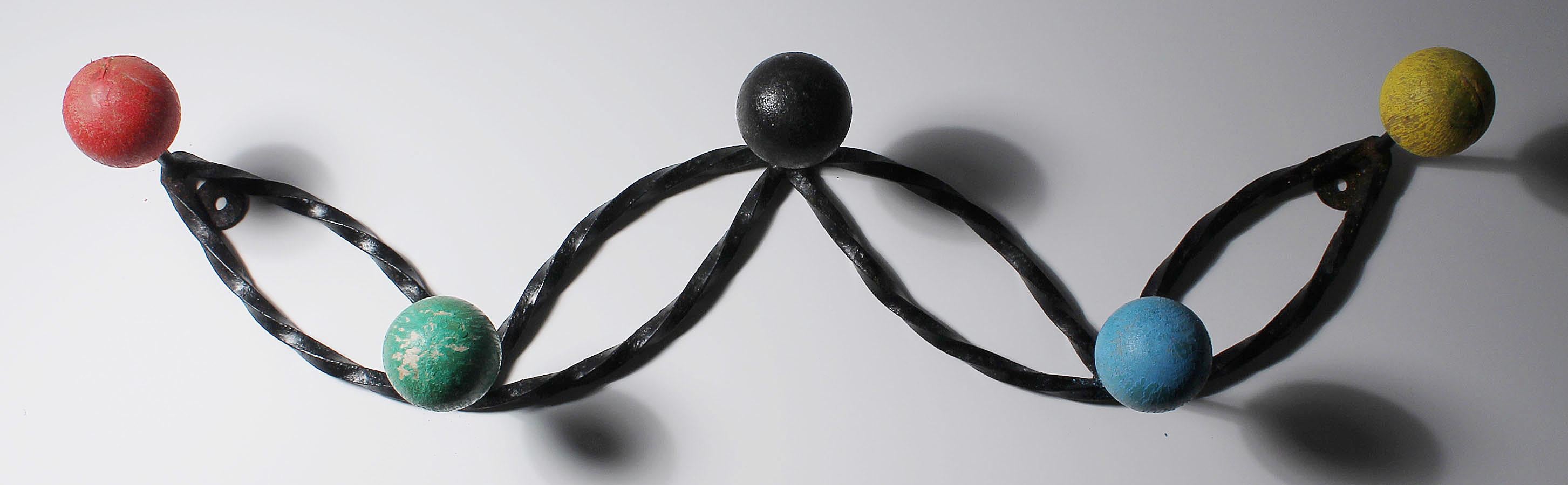 A French modern wall mountable coat rack with colorful painted wood spheres. A decorative twisted wrought iron frame. Appears to be original paint. Style of Jean Royere and Roger Feraud. coatrack