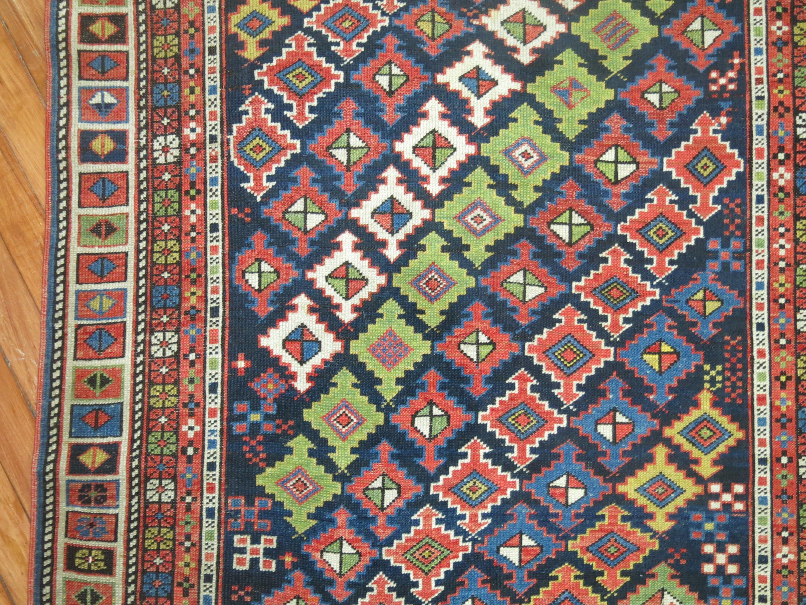 Early 20th century Antique Caucasian rug with a dazzling color combination on a navy ground. Very light and can be used as a wall hanging.

Measures: 3'5