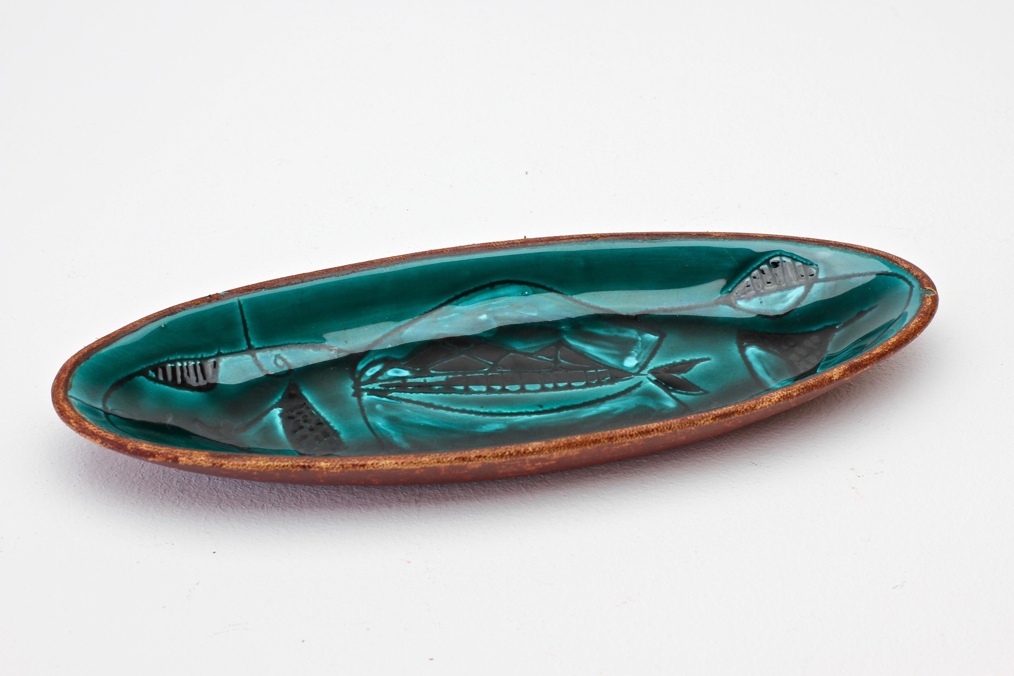 A beautiful ceramic serving bowl, dish or vide-poche wrapped and bound in a reddish brown stained leather, made in Italy, circa late 1950s-early 1960s, in the style of Marcello Fantoni.

Featuring a wonderful artistic design of fishes. Would be
