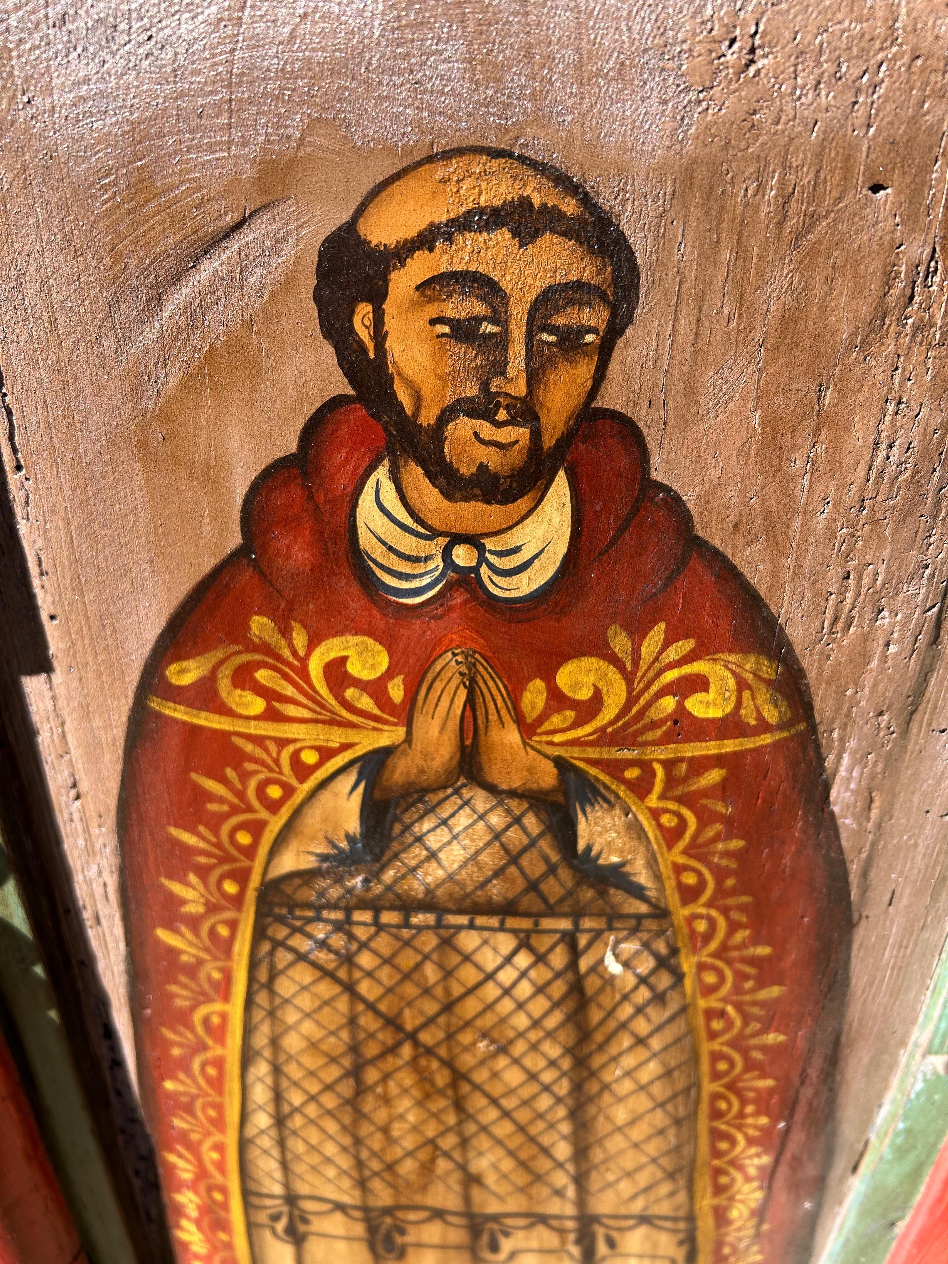 Eye catching colorful folk art rendering of a religious icon in typical Mexican primitive style on reclaimed wood and found materials.