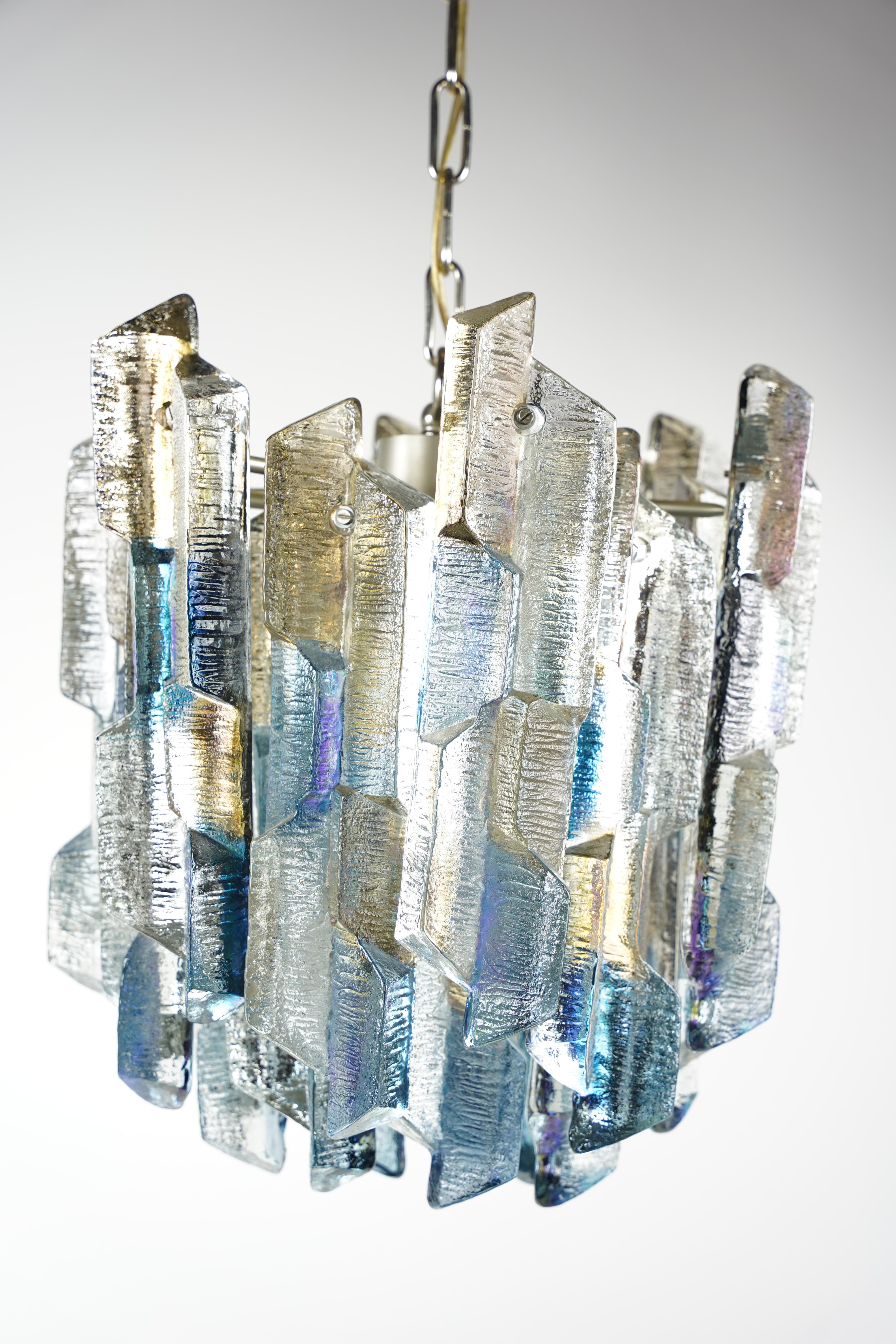 Kalmar chandelier, Vienna, Austria, 1970.
Metal frame with 18 individual frosted thick ice looking colored glass elements that has blue and yellow tint to them, original production/serial stickers inside the canopy.

6 candelabra sockets and one