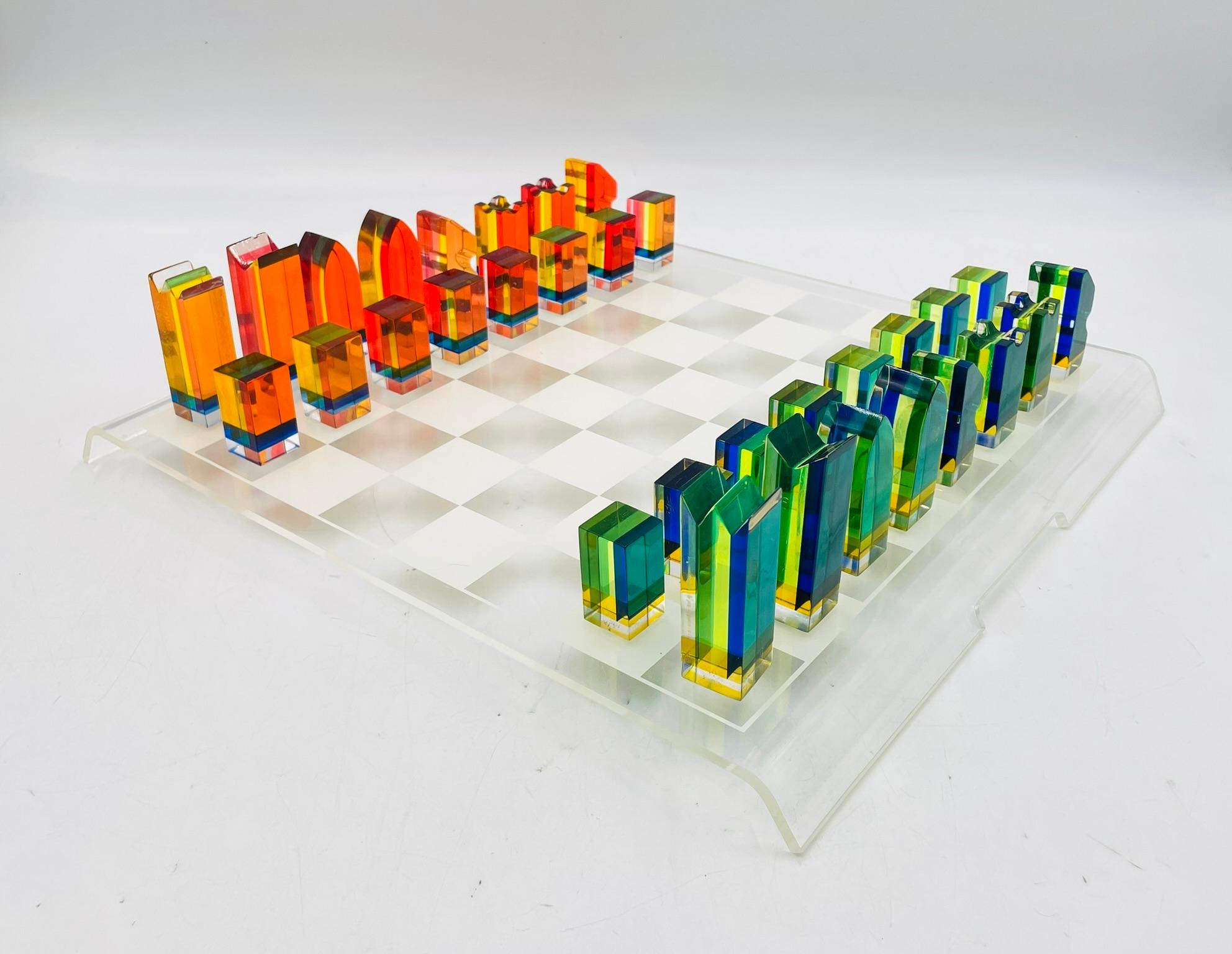 A rare and visually striking Lucite chess set designed by Charles Hollis Jones, a celebrated American designer known for his innovative work with acrylic and Lucite. Created circa 1960s, this set features vibrantly colored pieces in geometric