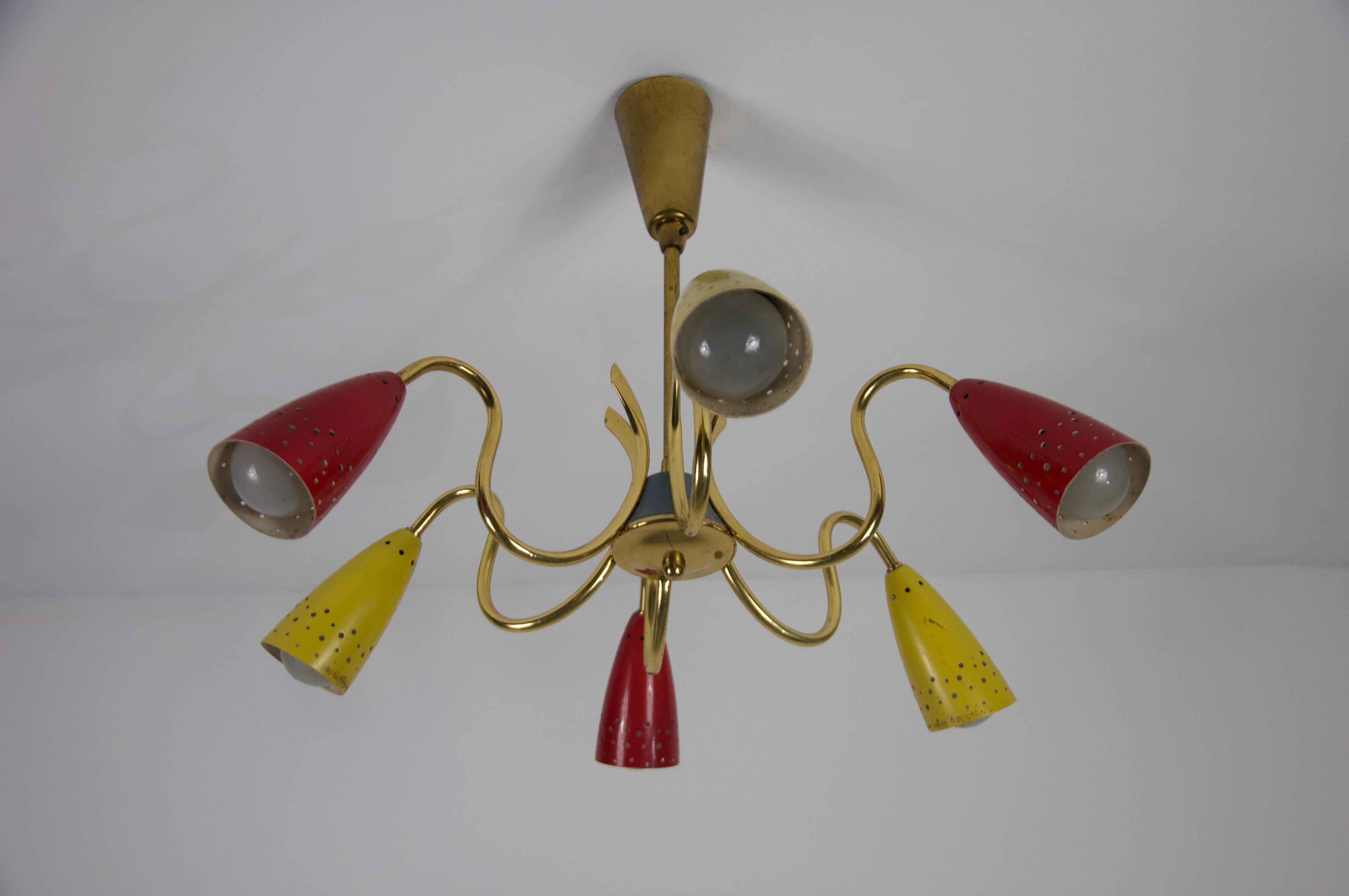 Superbe lustre Sputnik moderne des années 1950. Doté d'un corps en laiton épuré et de six bras, ce lustre respire la sophistication et le charme rétro. Les têtes de lampe perforées, finies dans des tons rouges et jaunes vibrants, créent non
