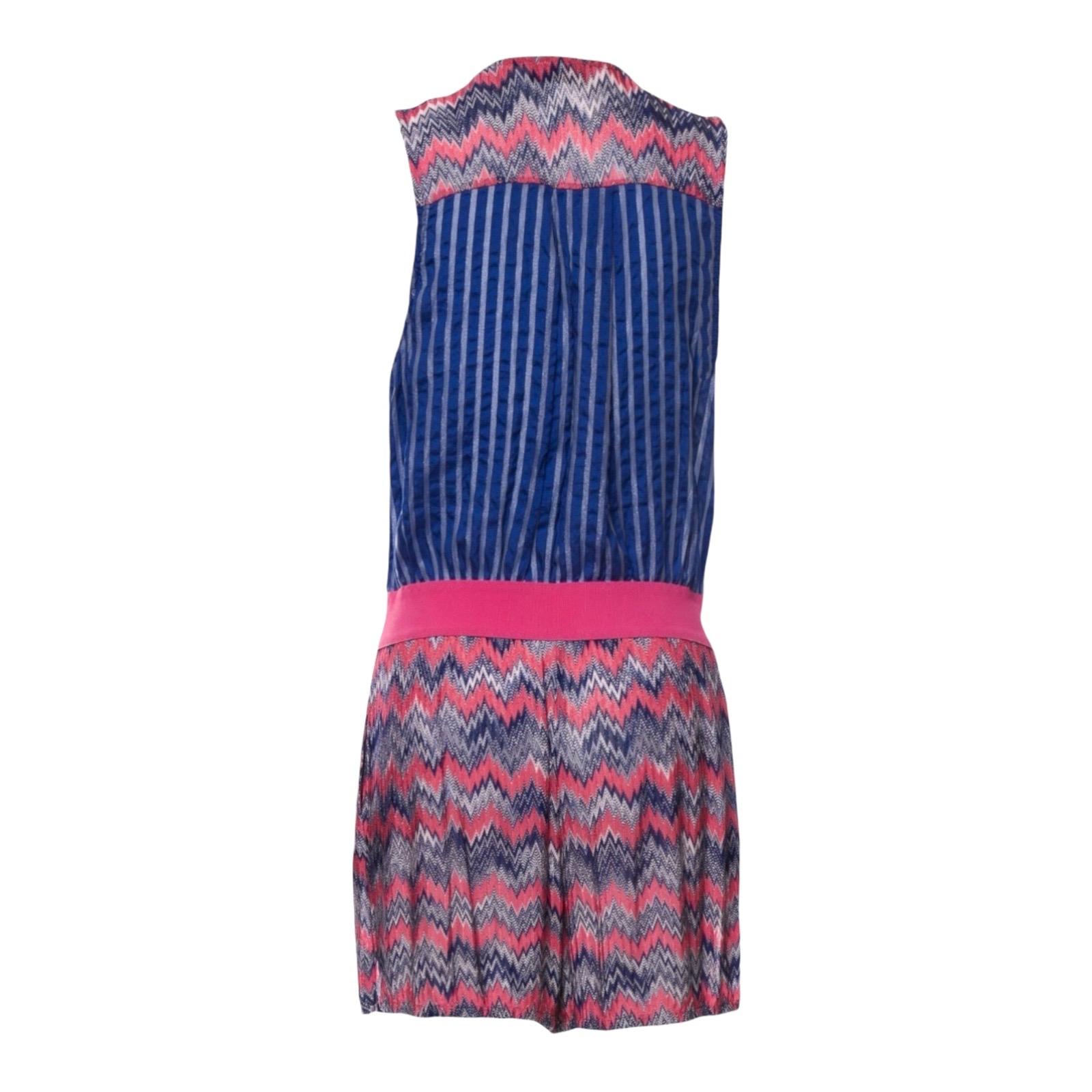 Dieser von Missoni entworfene Playsuit mit seinem charakteristischen Webmuster ist einfach zu elegant, um ihm zu widerstehen! 
Dazu gehört ein rosa und blau gestreiftes Oberteil mit Knopfleiste. Es hat einen Rundhalsausschnitt und ärmellose Arme.