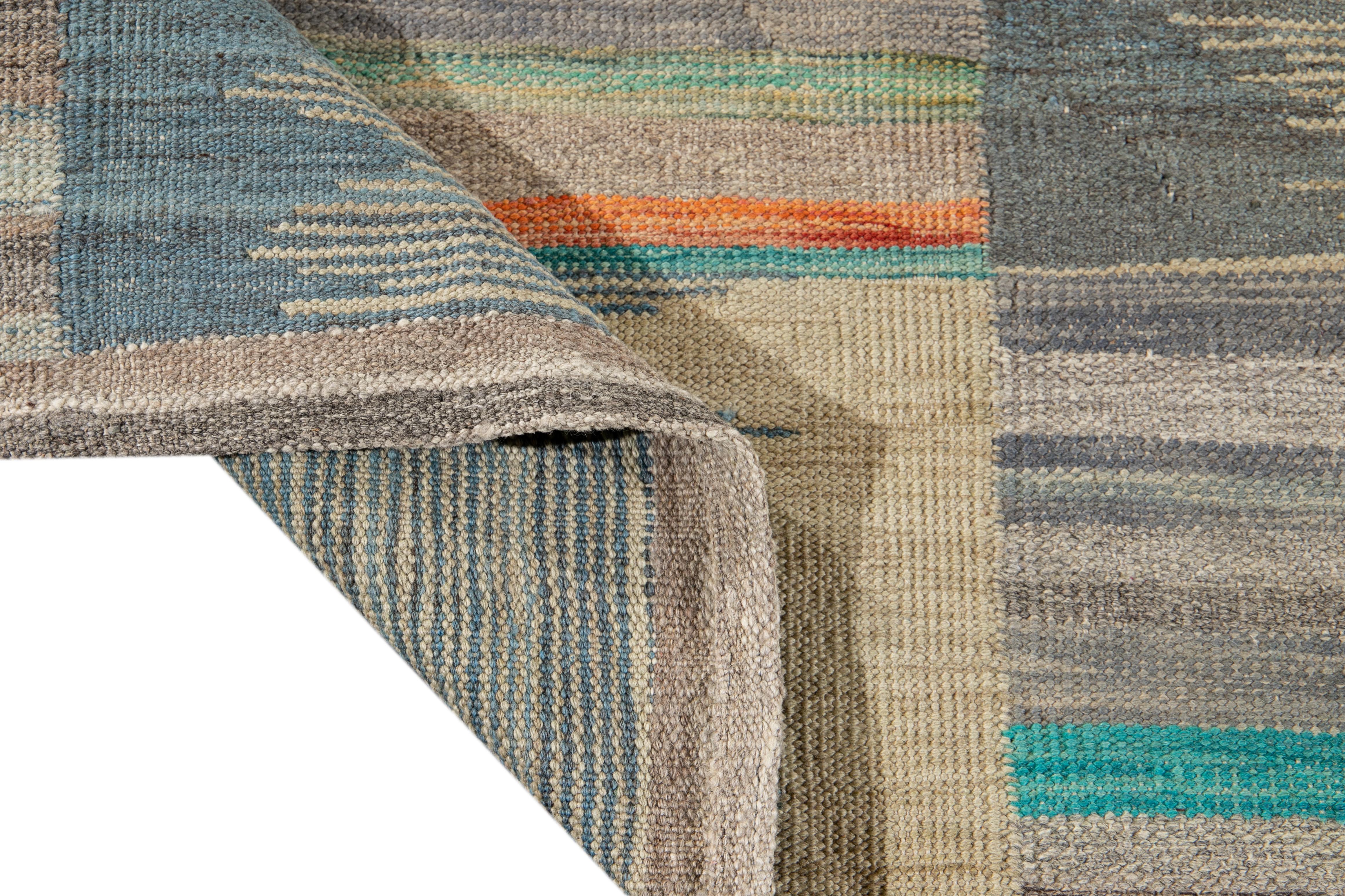 Schöner moderner flachgewebter Kilim-Teppich aus handgefertigter Wolle. Dieser Kelim-Teppich hat ein graues Feld und mehrfarbige Akzente in einem herrlichen geometrischen Muster.

Dieser Teppich misst: 8'9