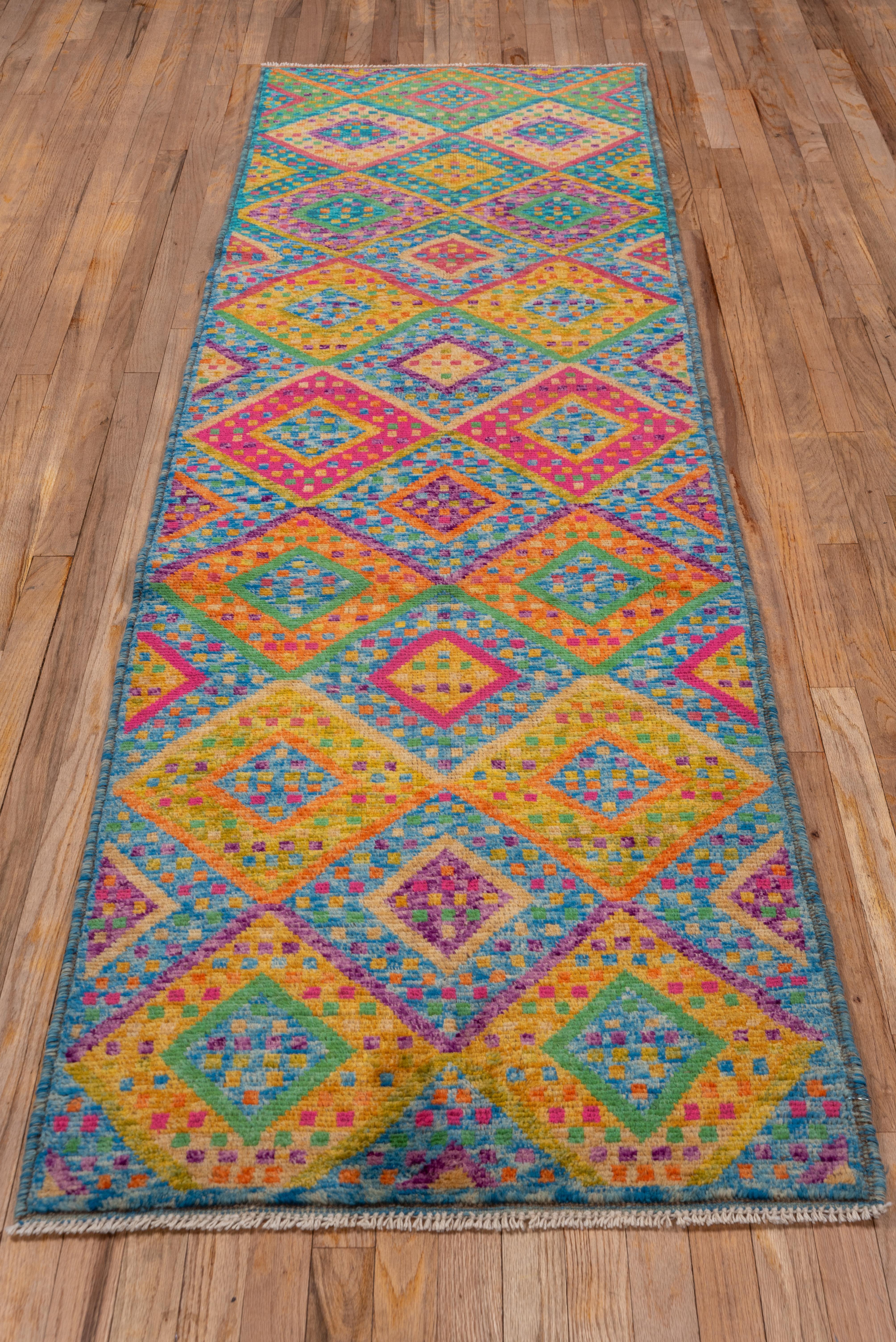 This modern runner has shades of goldenrod, marigold, aqua, royal blue, sky blue and green and are attractively broken on this abstractly patterned, borderless short runner with a two column design of nested sand internally dotted diamonds, with