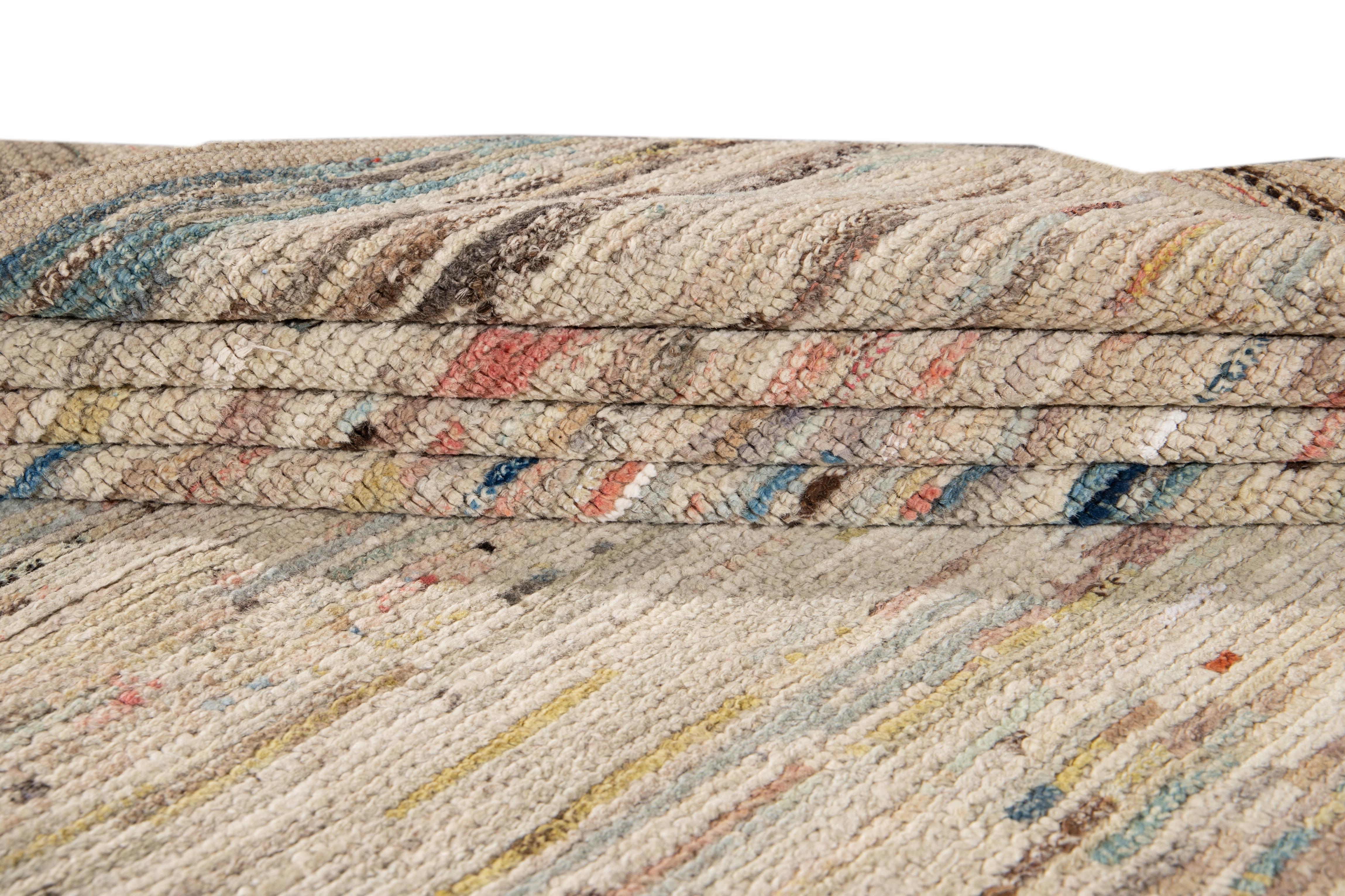 Magnifique tapis de style marocain en laine nouée à la main avec un champ ivoire. Ce tapis présente des accents multicolores dans un superbe motif géométrique abstrait.

Ce tapis mesure 7'6