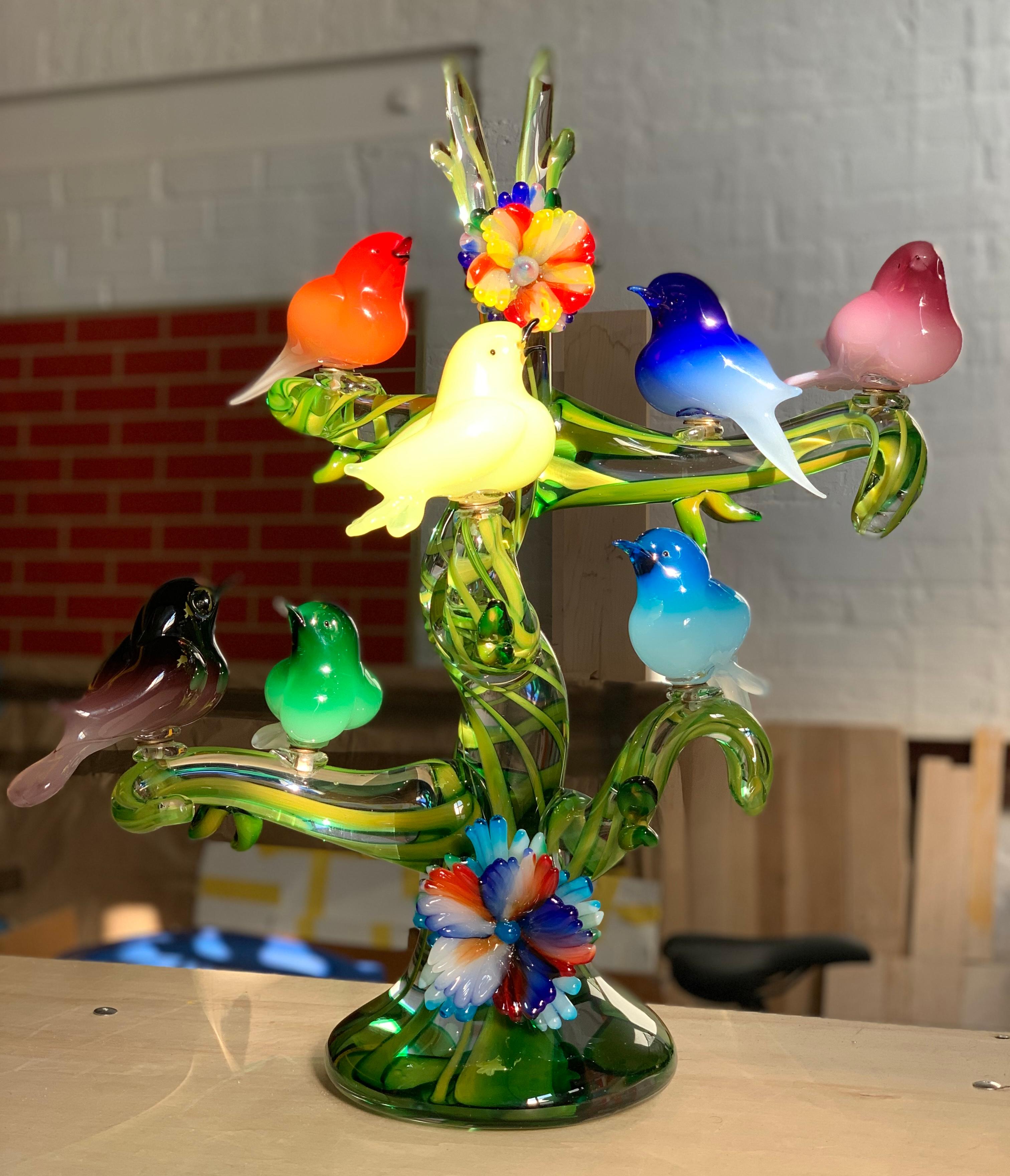 Colorful murano glass birds in a tree sculpture, Enrico Cammozzo, Italy, 1970s. Gorgeous monumental piece. Murano Italian art glass bird sculpture. Enrico Cammozzo (Italian, born 1965). Seven birds perched on a tree bearing two large glass flowers.