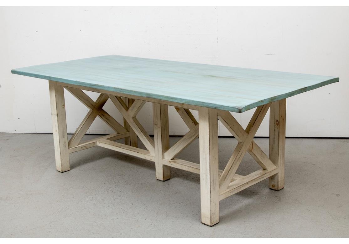 A Colorful and very well made Table having a Breezy and Casual appearance. With an intentional distressed finish top in pale Turquoise paint. Raised on an elaborate base with H stretcher and X form supports on the ends. Double angled supports in the