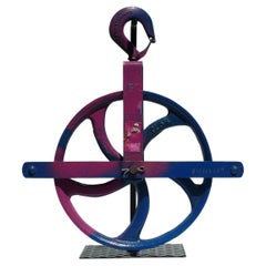 Colorful Painted Bright Blue Large Industrial Cast Iron Pulley on a Metal Base