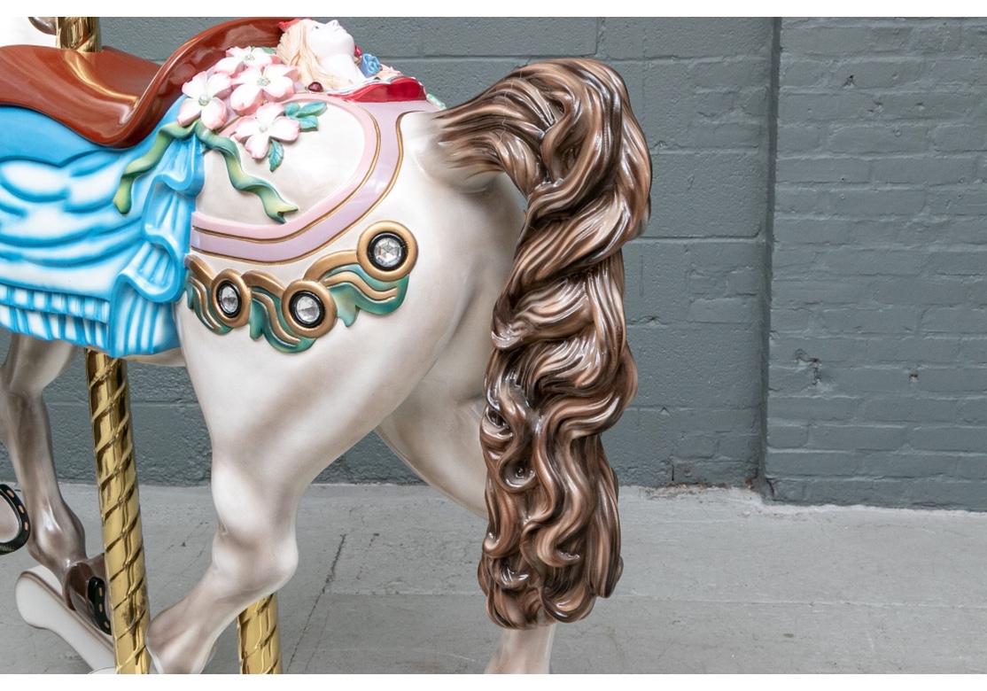 A remarkable large scale painted rocking horse decorated in the manner of a carousel horse. The white horse with brown mane and tail wears a red saddle on a blue blanket. The rump is decorated with a blond female mask flanked by pink and white