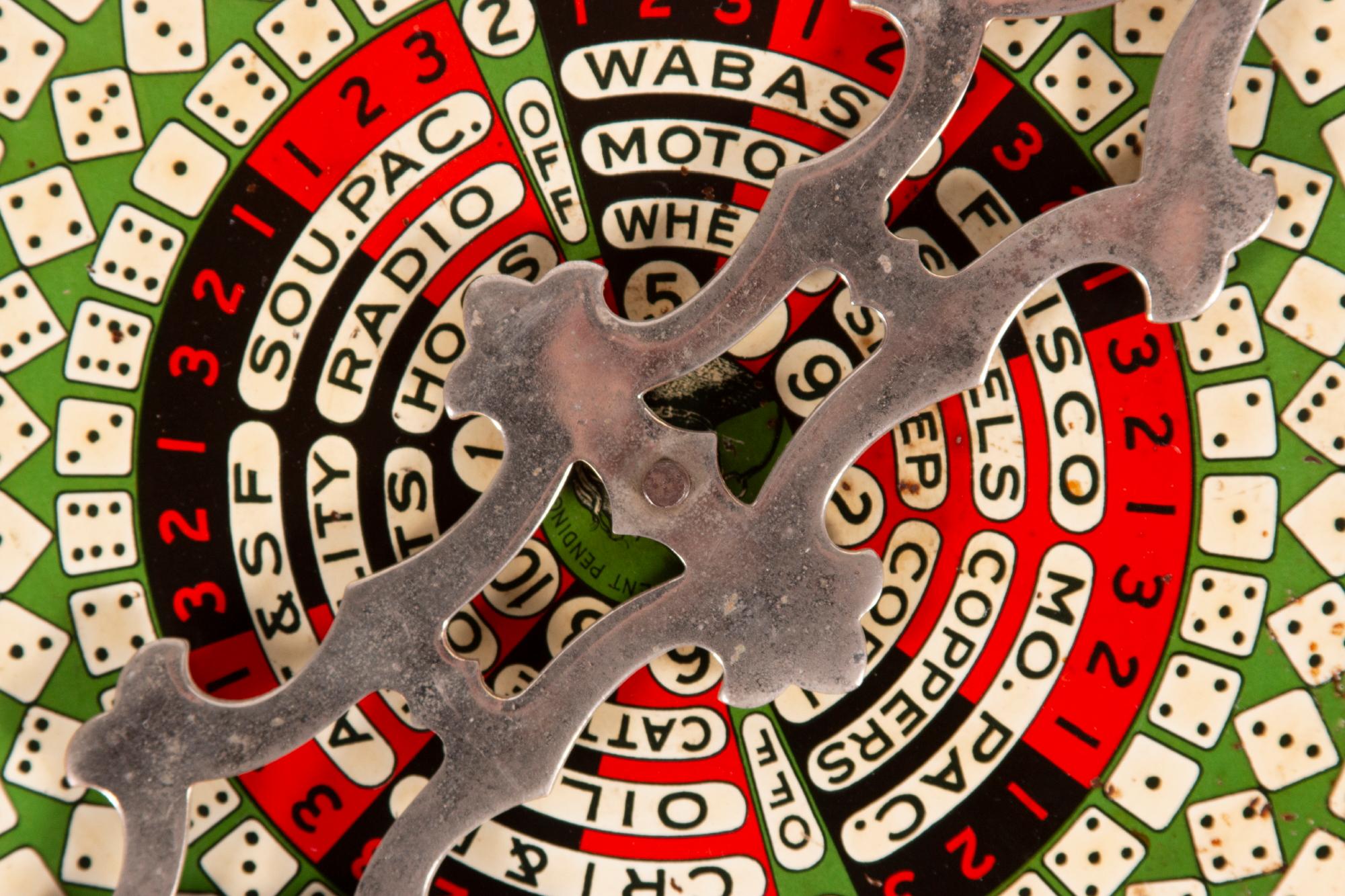 COLORFUL PAINTED SHEET METAL GAME WHEEL ON A SHAPED WOODEN FRAME WITH A NICKLE-PLATED SPINNER, circa 1890-1910

Red, black, white, and green game wheel with a horse head in the center beneath a large and elaborate, nickel-plated, removable