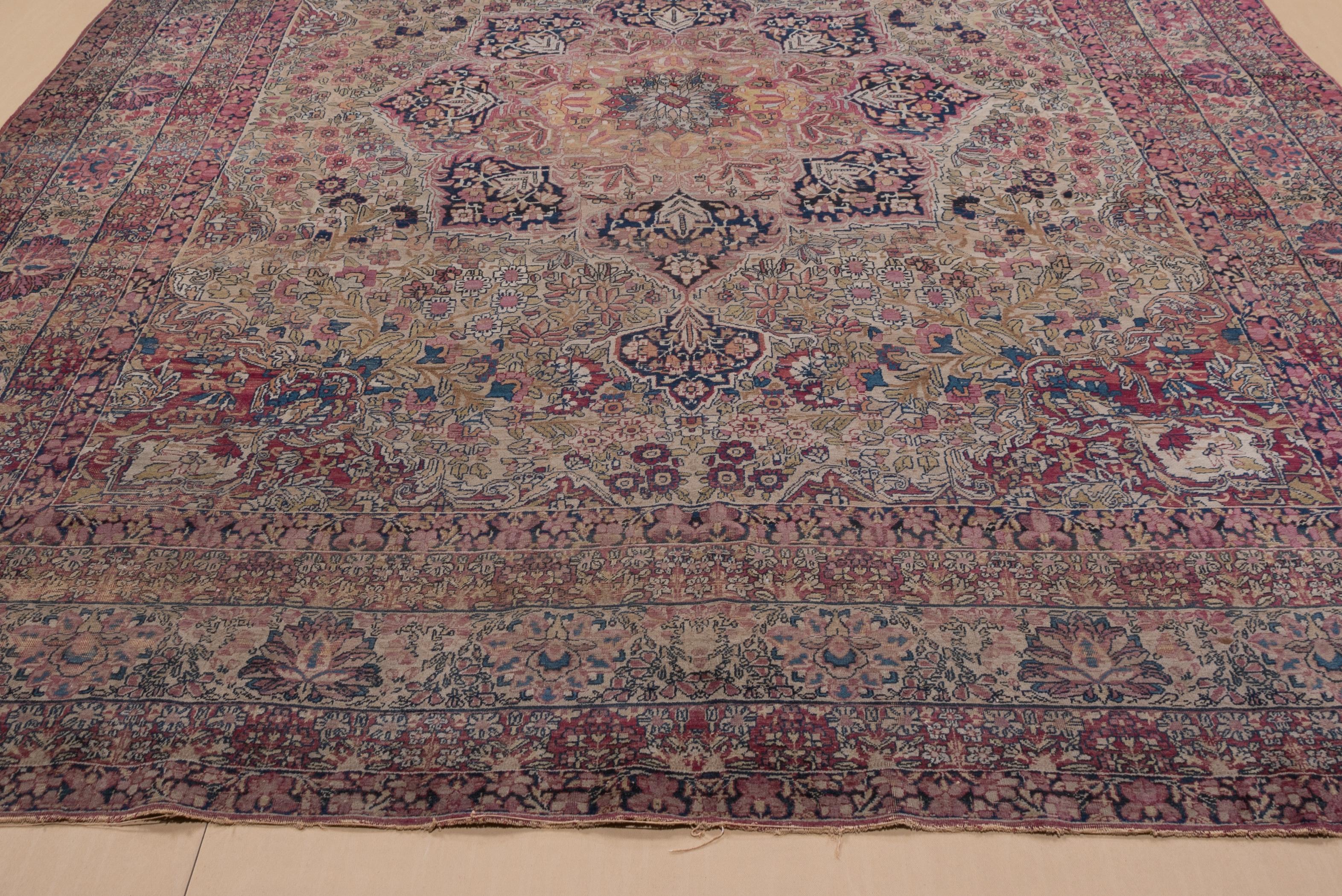 This attractively toned SE Persian city carpet displays a very wide palette of yellow, sand, cochineal red, rose, various blues, teal and pistachio in the field and navy elaborate layered octogram medallion. The flowers are often semi-realistically
