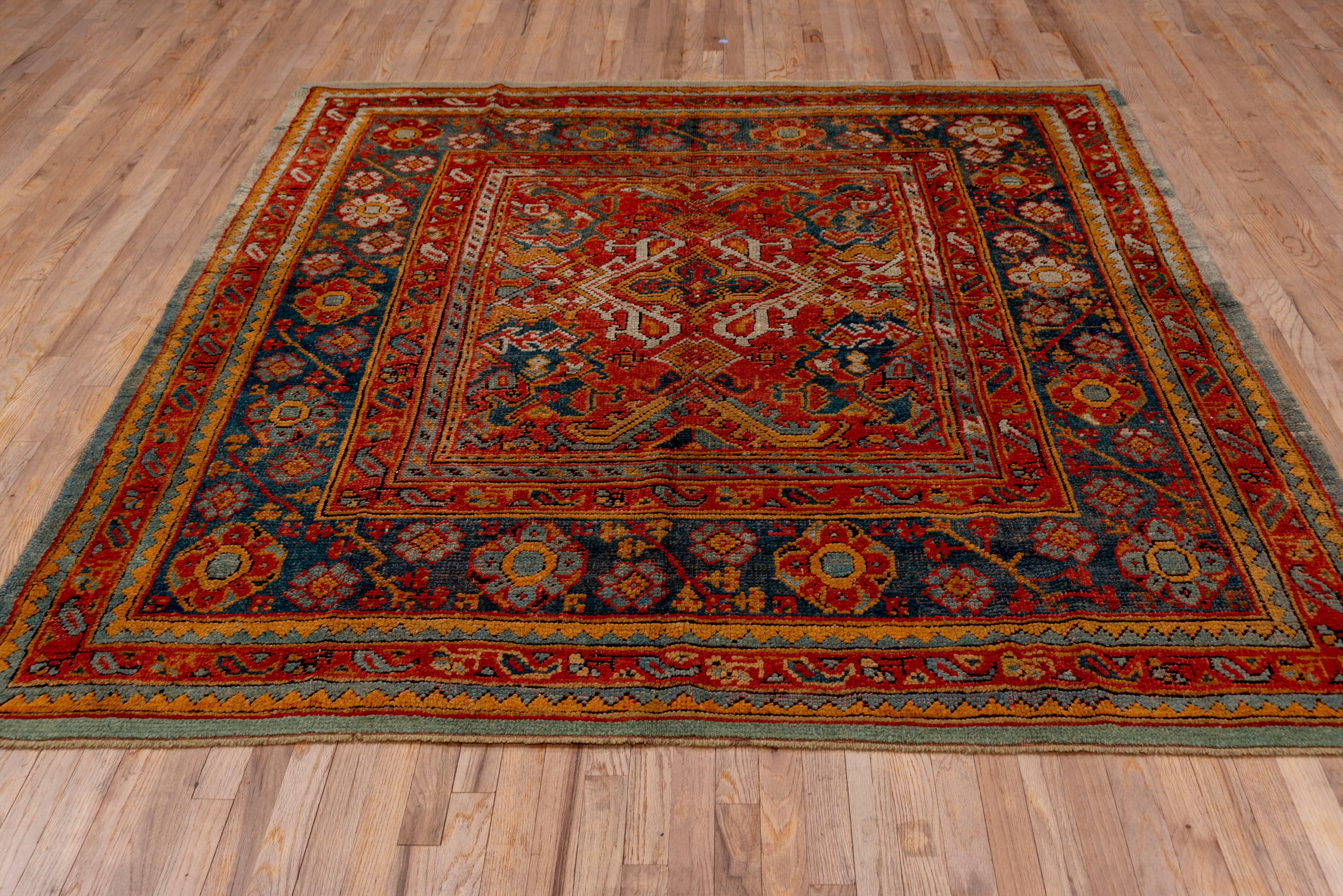 This antique Oushak has a rich palette but is subdued at the same time. The large-scale Smyrna design in the field has been centred to give it balance and is complimented by a rosette and vine main border. This rug was woven in West Central Turkey.