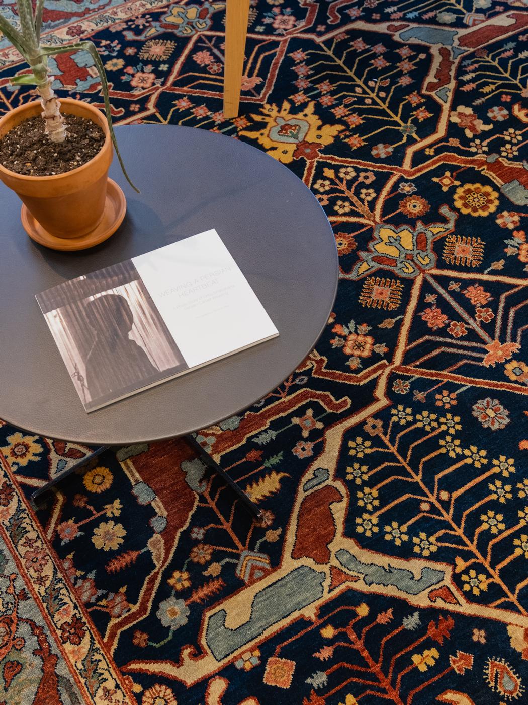 Dieser handgeknüpfte Serapi-Teppich aus blauer, rosafarbener, roter, goldener, brauner und grüner Wolle hat einen tiefen indigoblauen Hintergrund und ein geometrisches Blumenmuster, das über die gesamte Fläche verteilt ist. Er misst 8'1