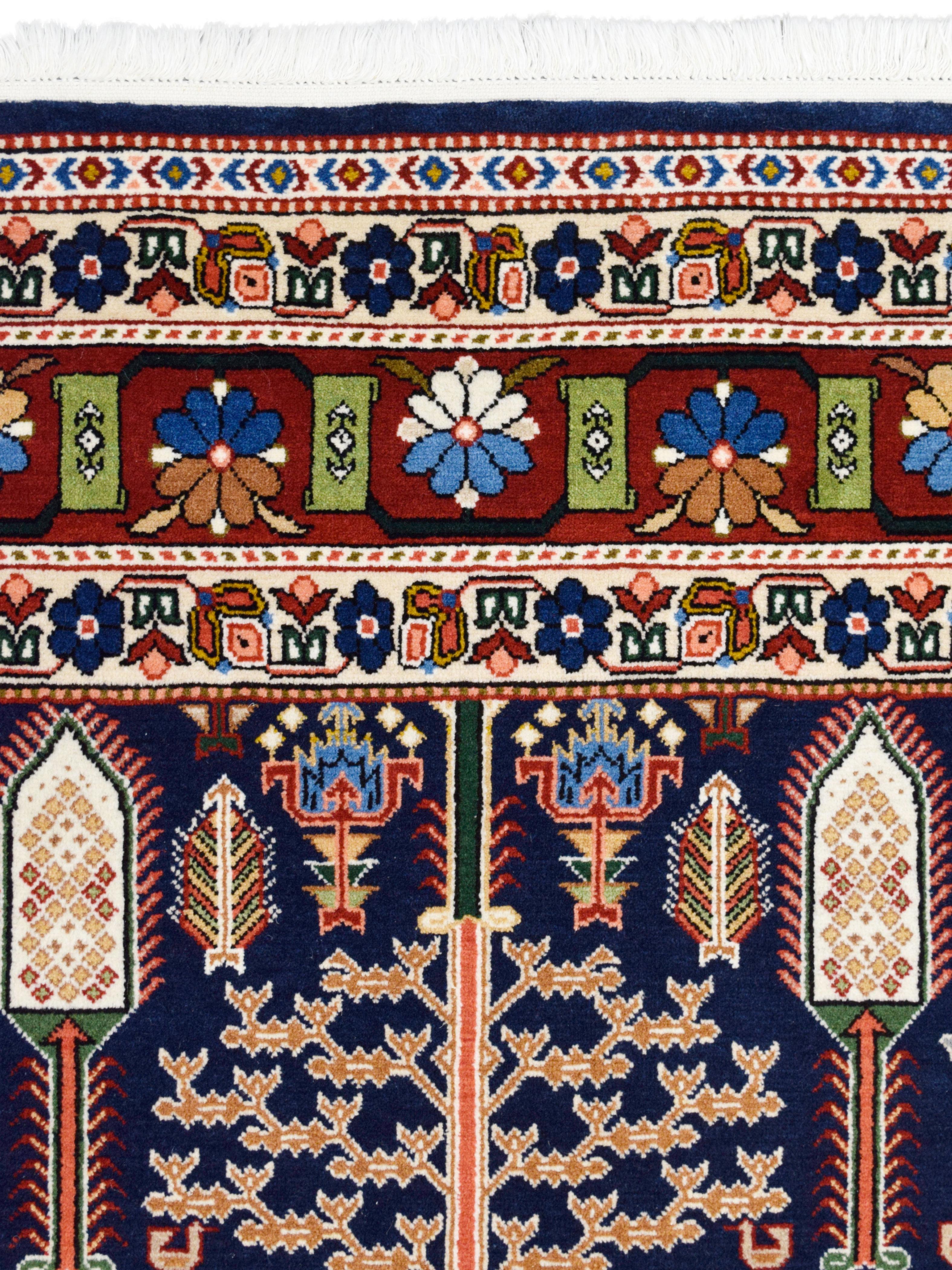 Measuring 5’5” x 8’3”, this colorful Tree-of-Life Bakhtiari carpet is hand-knotted in blue, red, green, pink, and taupe wool and illustrates a tribal-inspired garden design. Unique compared to traditional Persian Bakhtiari carpets, this piece