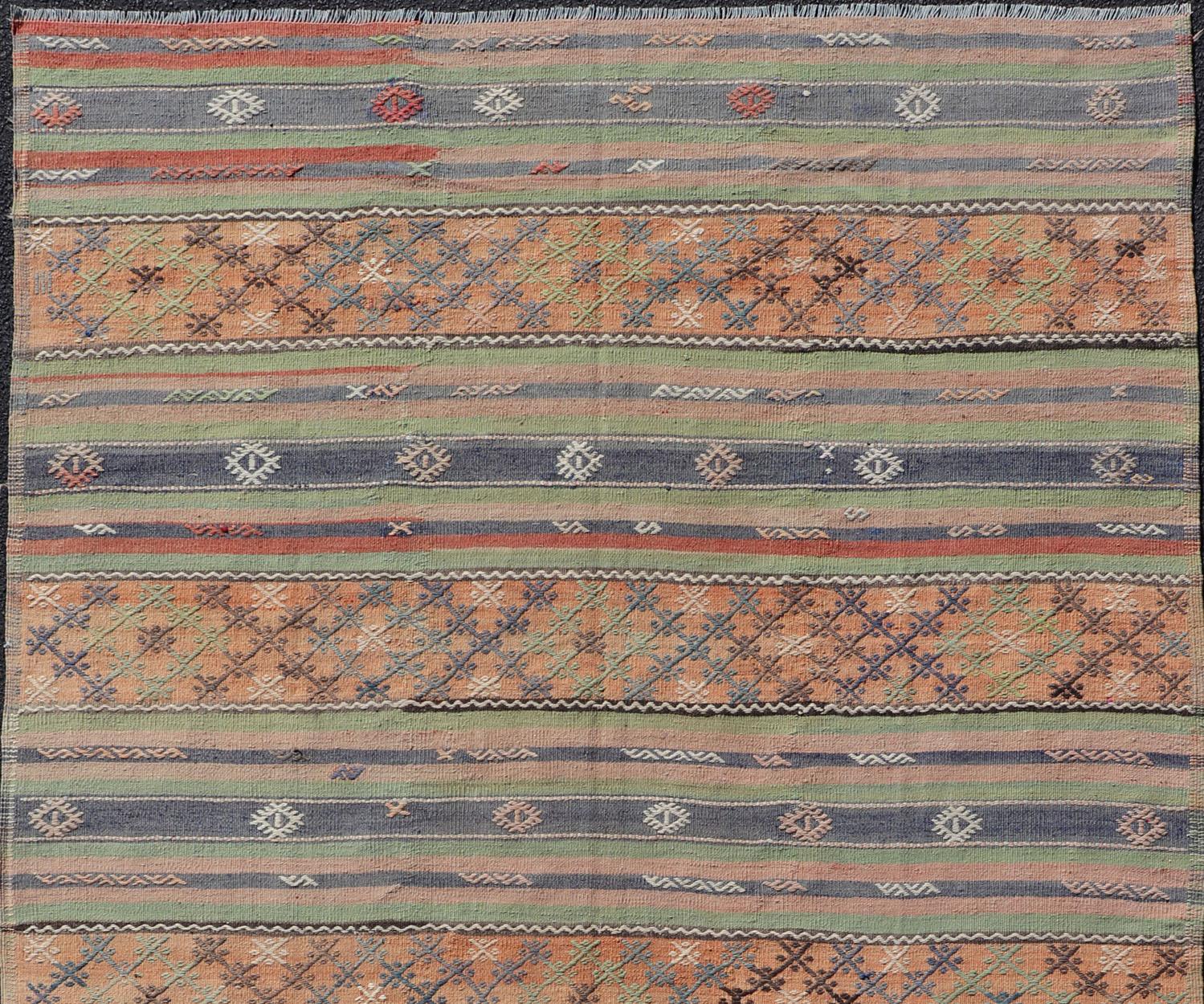 Colorful Turkish Kilim rug with stripes and geometric elements, rug TU-NED-1034, country of origin / type: Turkey / Kilim, circa mid-20th century

Featuring geometric shapes rendered in a repeating horizontal stripe design, this unique Mid-Century