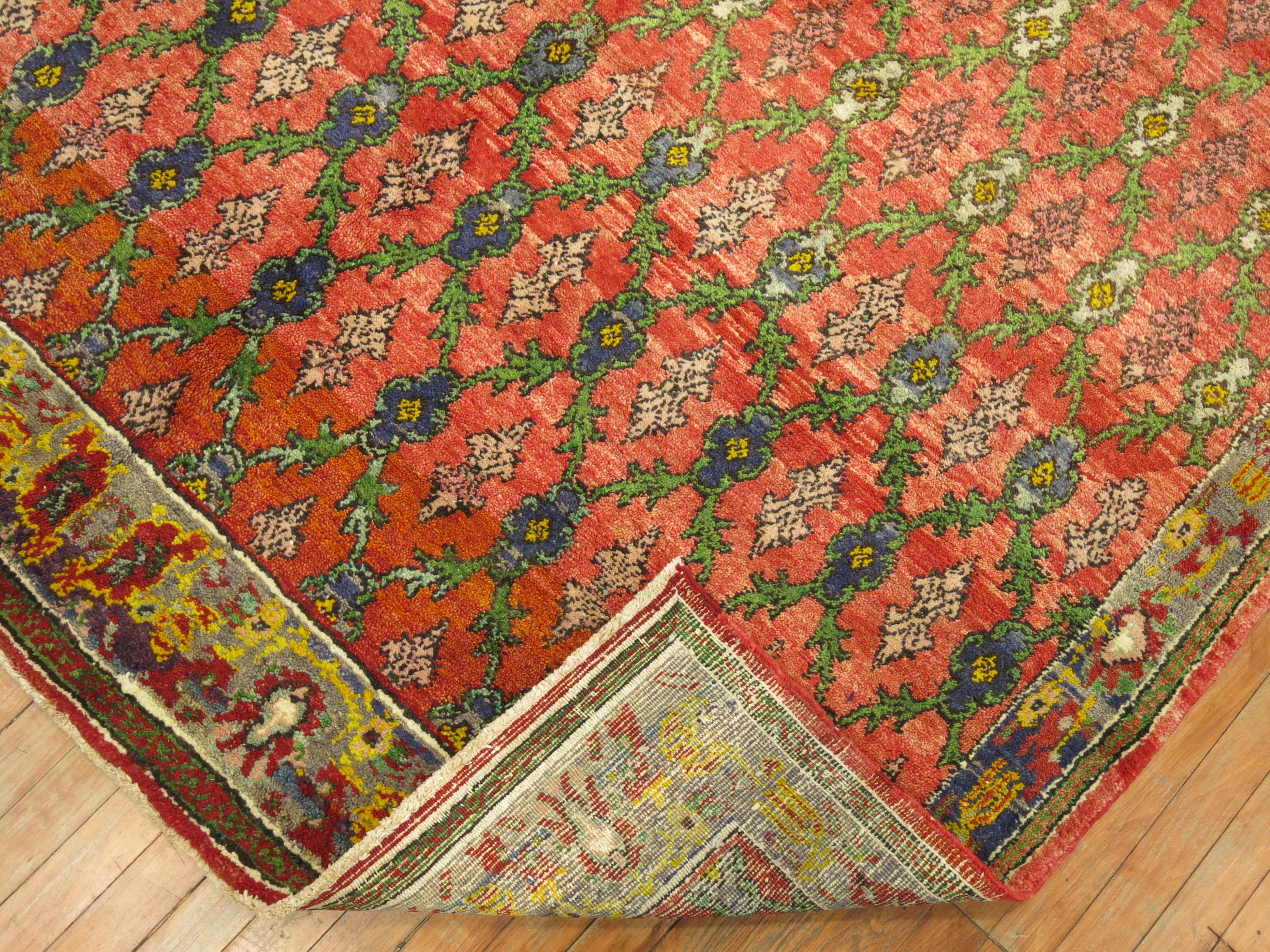 mid 20th century colorful Turkish Konya rug with a repetitive floral design on a red ground

Measures: 6'2''x 9'2''.