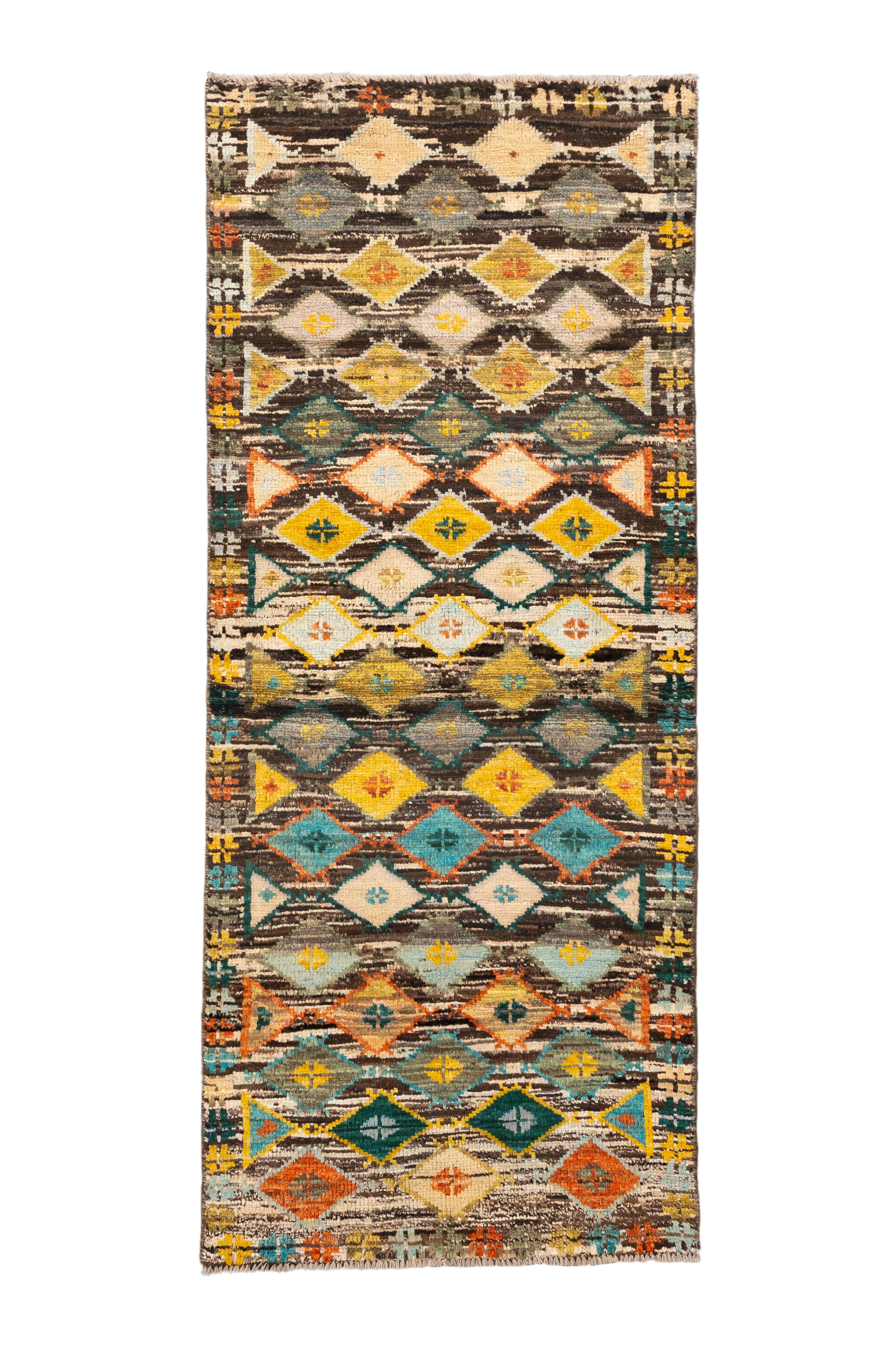  Una exuberante alfombra NUEVA Tulu turca con filas apiladas de atrevidos medallones de diamantes en un caleidoscopio de tonos: azafrán, ocre, verde azulado, marfil, canela y esmeralda. Cada banda de motivos presenta una variación de forma y color,