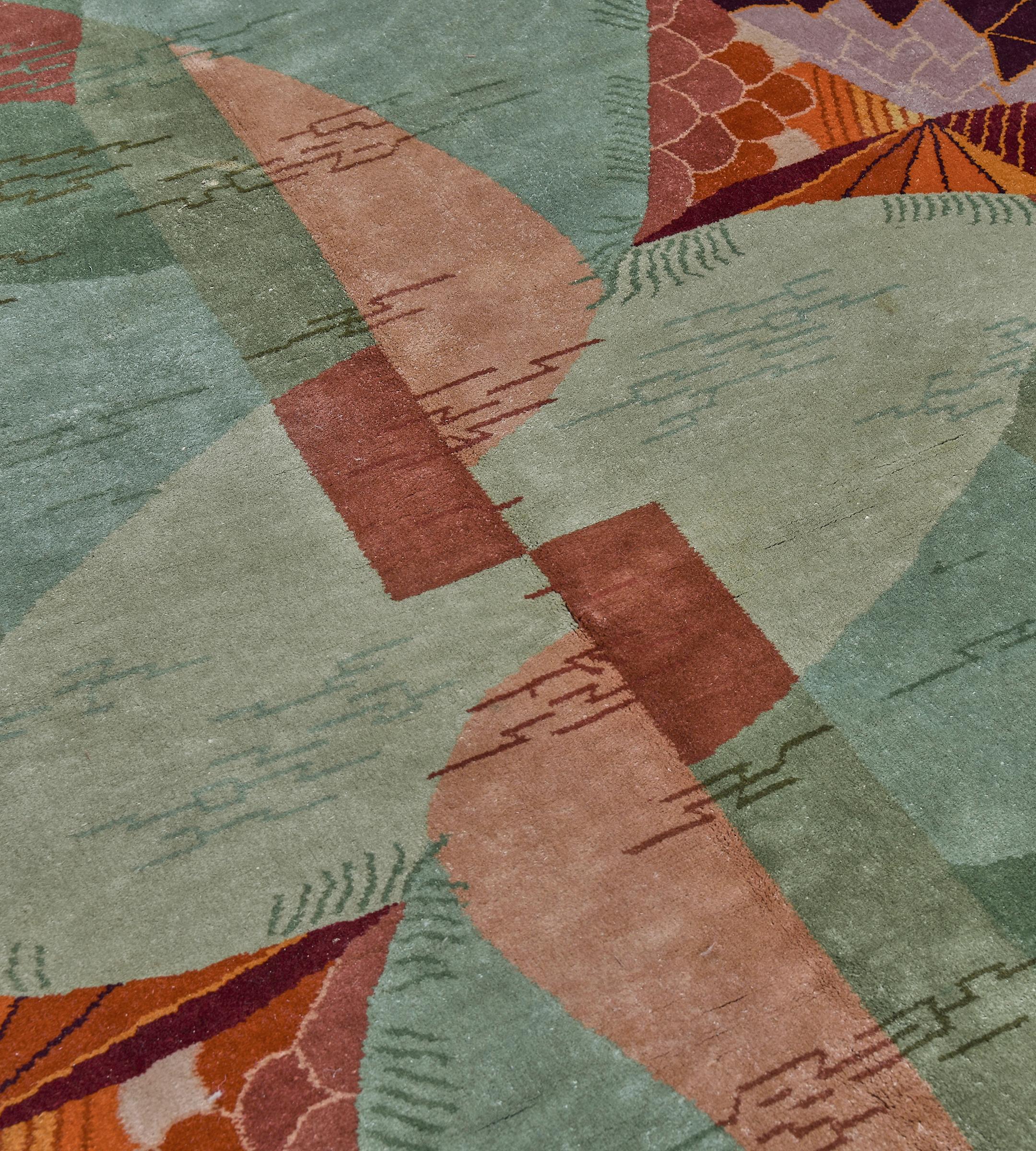 This handwoven Chinese Deco rug has shaded shapes of soft blue, rust, sage and coral overlaid by an unexpected violet, orange, and yellow geometric sunset patterns and abstract lines.

These rugs were primarily produced in China, notably in Tianjin