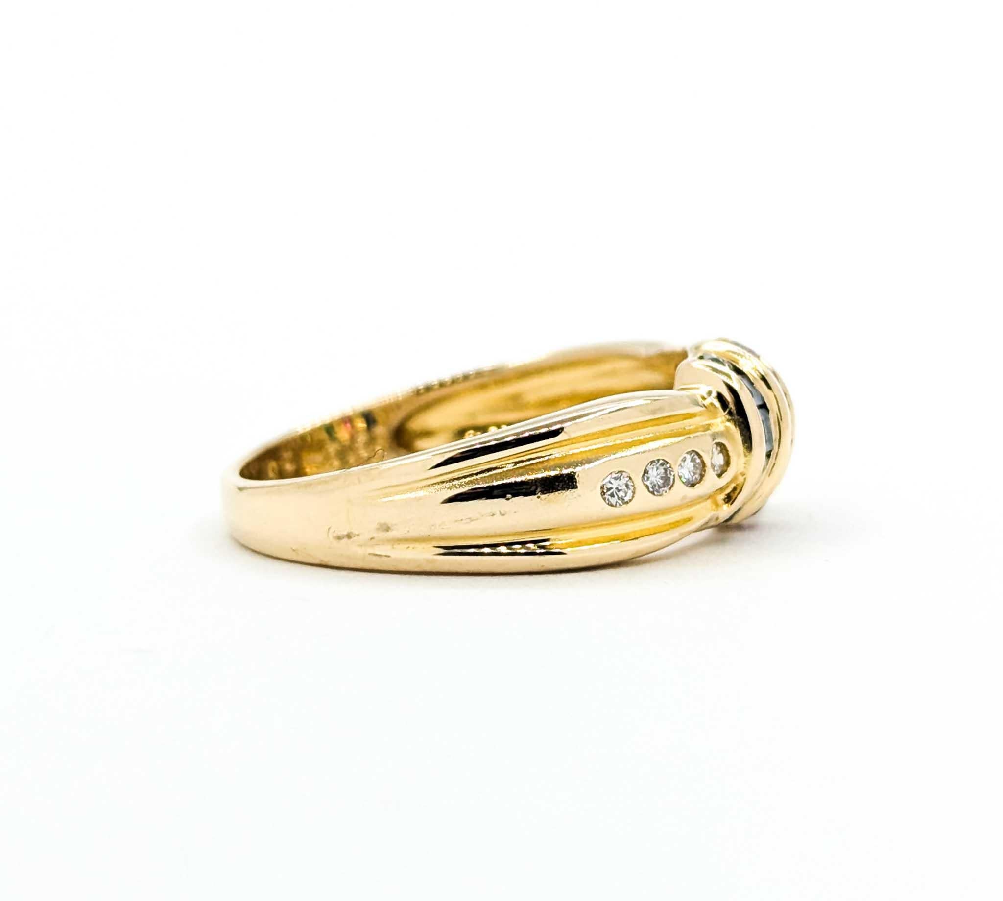 This colorful vintage ring is crafted in rich 18k yellow gold and showcases a striking combination of gemstones. At its center, channel-set rows of emerald (.08ctw), ruby and sapphire (.15ctw total), are flanked by sparkling round diamonds totaling