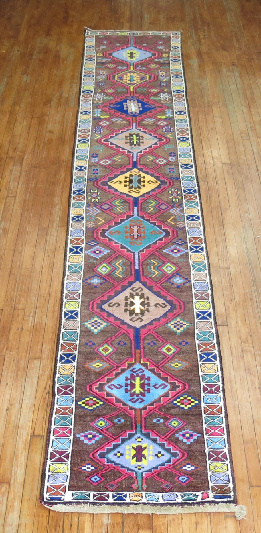 A long and narrow eclectic Turkish Anatolian runner with a flashy array of electric colors and geometric all-over design.