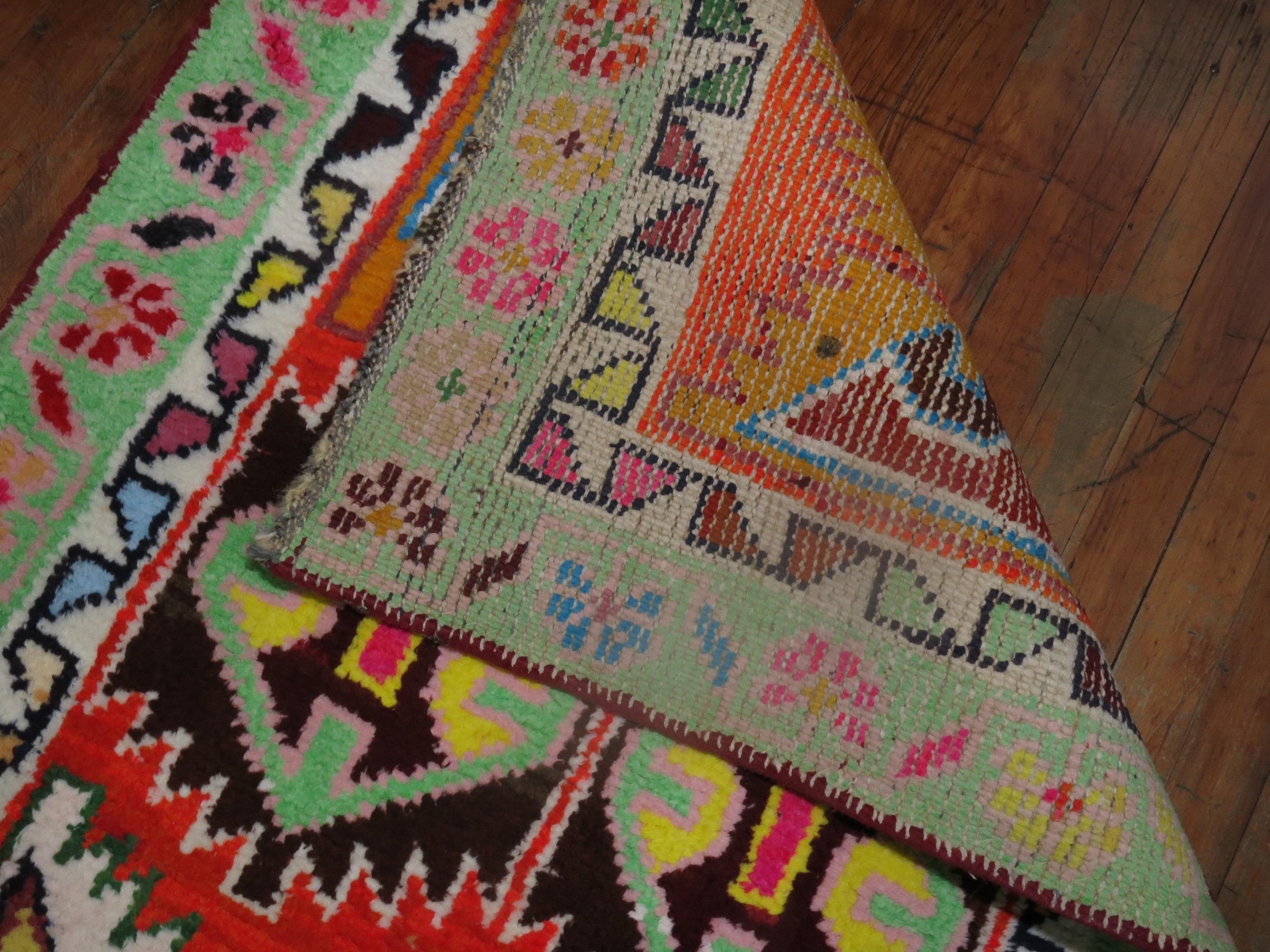 A long and narrow eclectic Turkish Anatolian runner with a flashy array of electric colors on a multicolored vibrant ground.